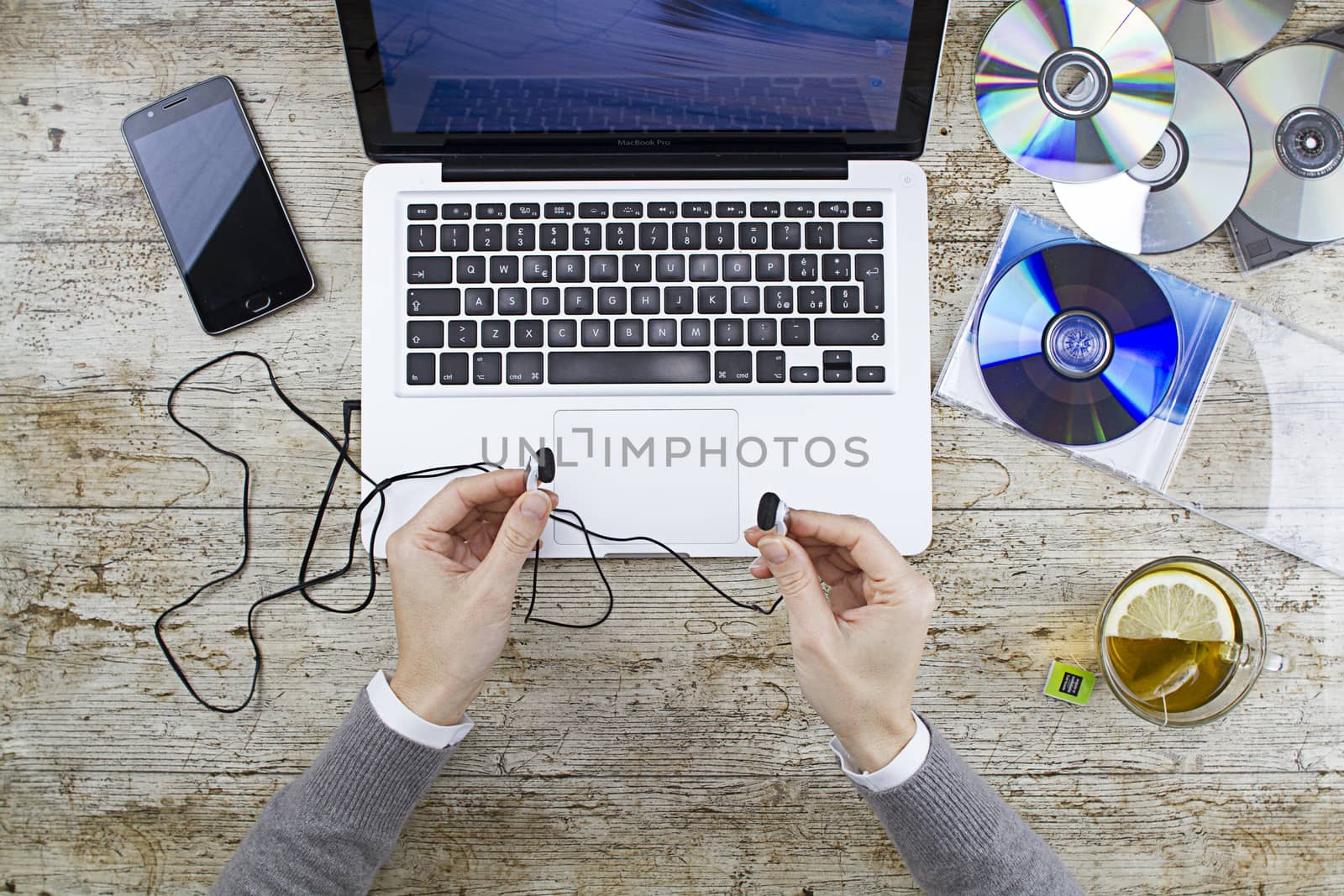 Young woman shooting from above working on laptop on wooden tabl by robbyfontanesi