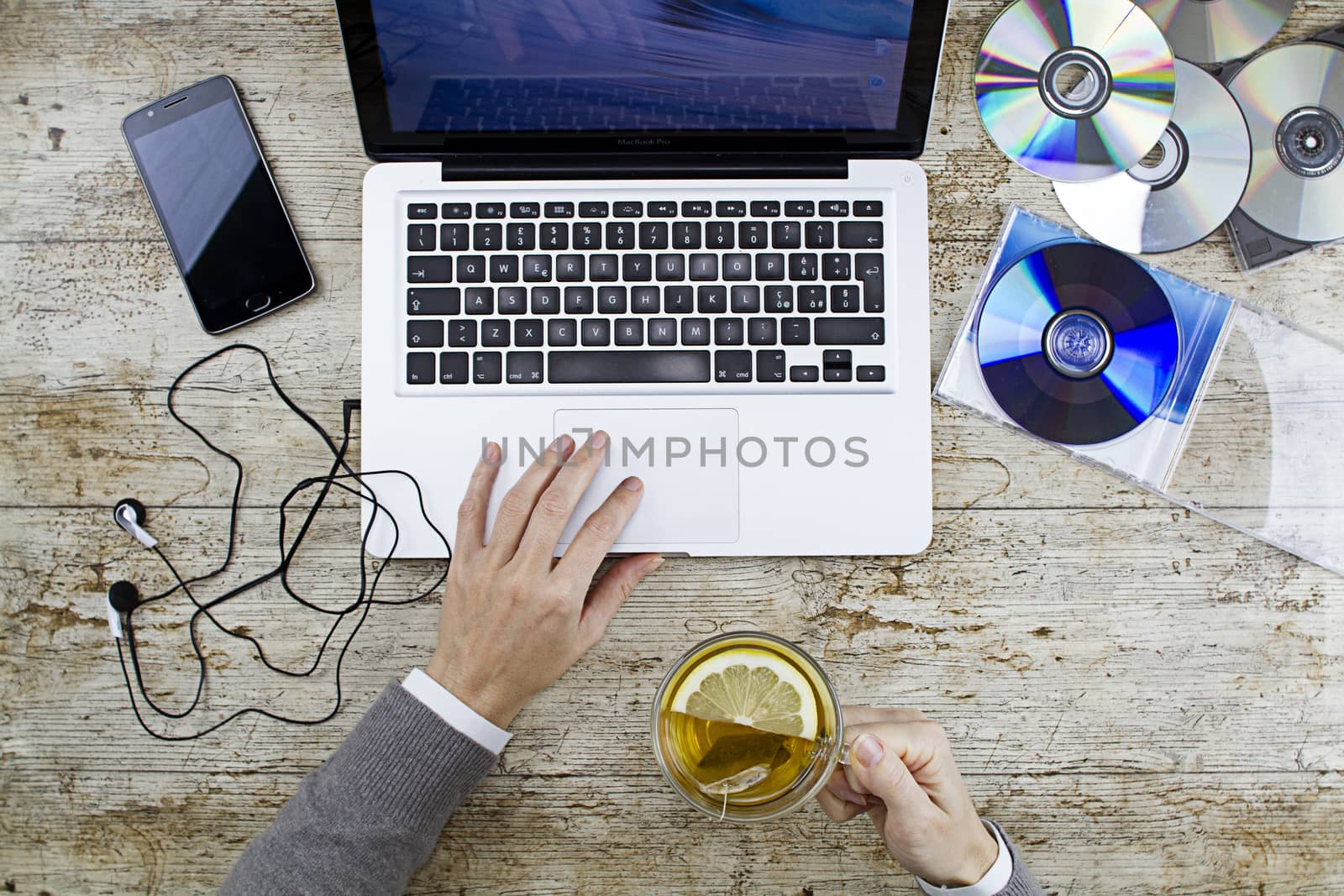 Young woman shooting from above working on laptop on wooden tabl by robbyfontanesi