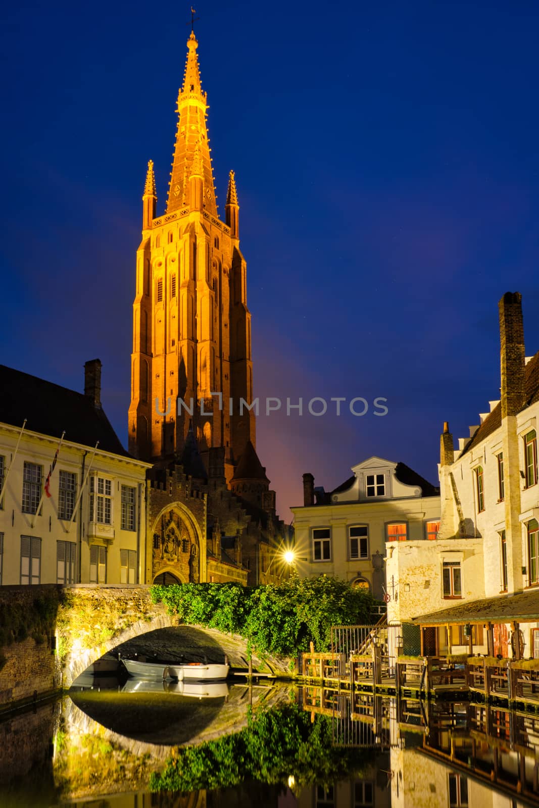 Church of Our Lady and canal illuminated in the night. Brugge Bruges, Belgium