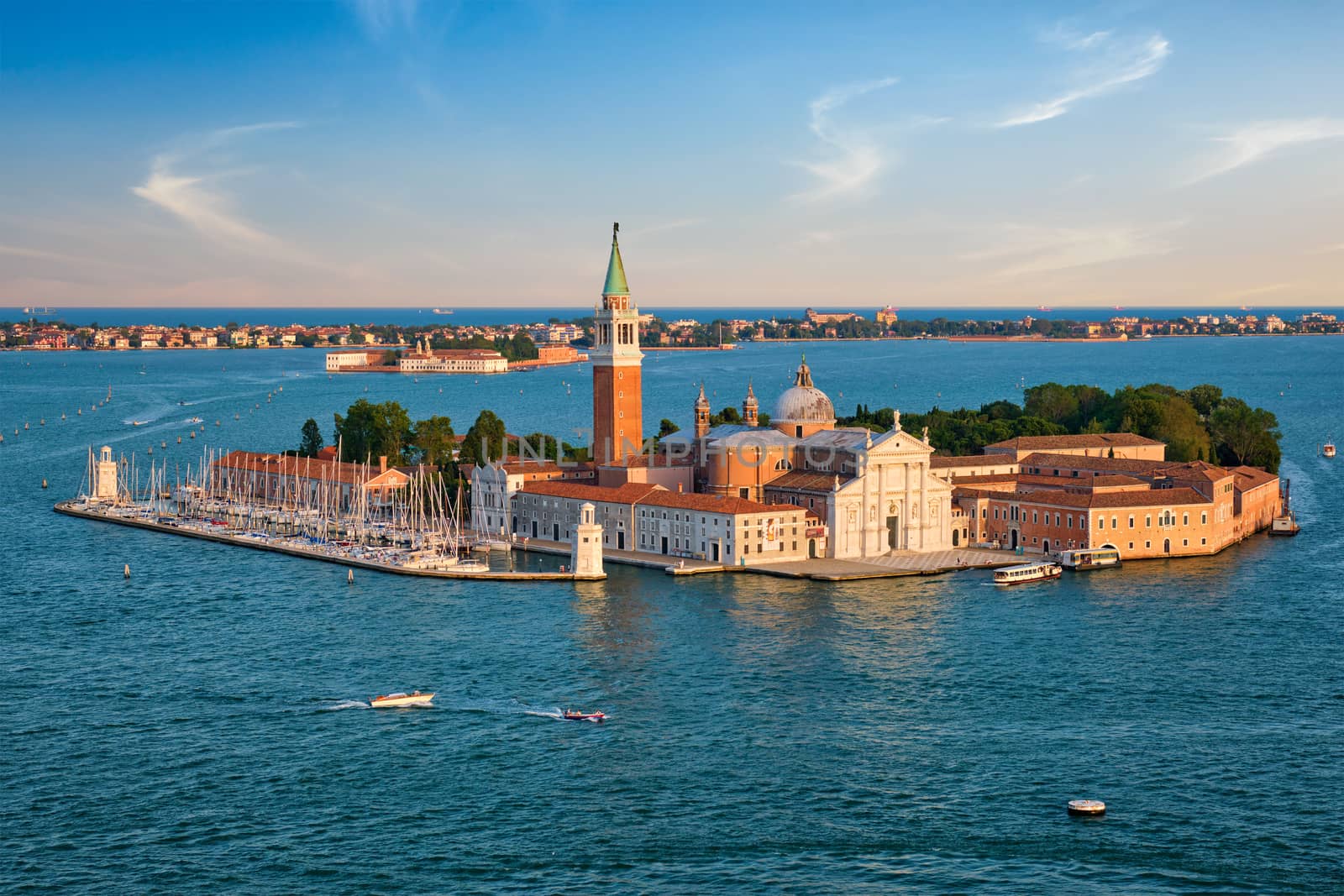 Famous Italy tourist destination - aerial view of Venice lagoon and San Giorgio di Maggiore church with boats and vaporetto traffic on sunset from St Mark's Campanile bell tower, Venice, Italy
