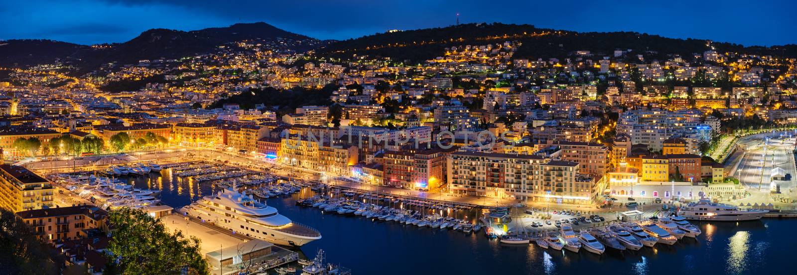 Panorama of Old Port of Nice with luxury yacht boats from Castle Hill, France, Villefranche-sur-Mer, Nice, Cote d'Azur, French Riviera in the evening blue hour twilight illuminated