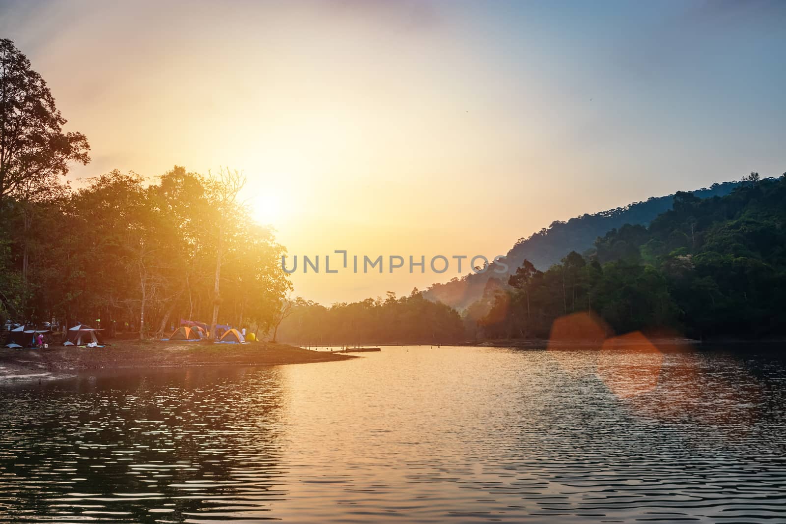 landscape of river view during the sunrise time with many colorful camping tent at campsite