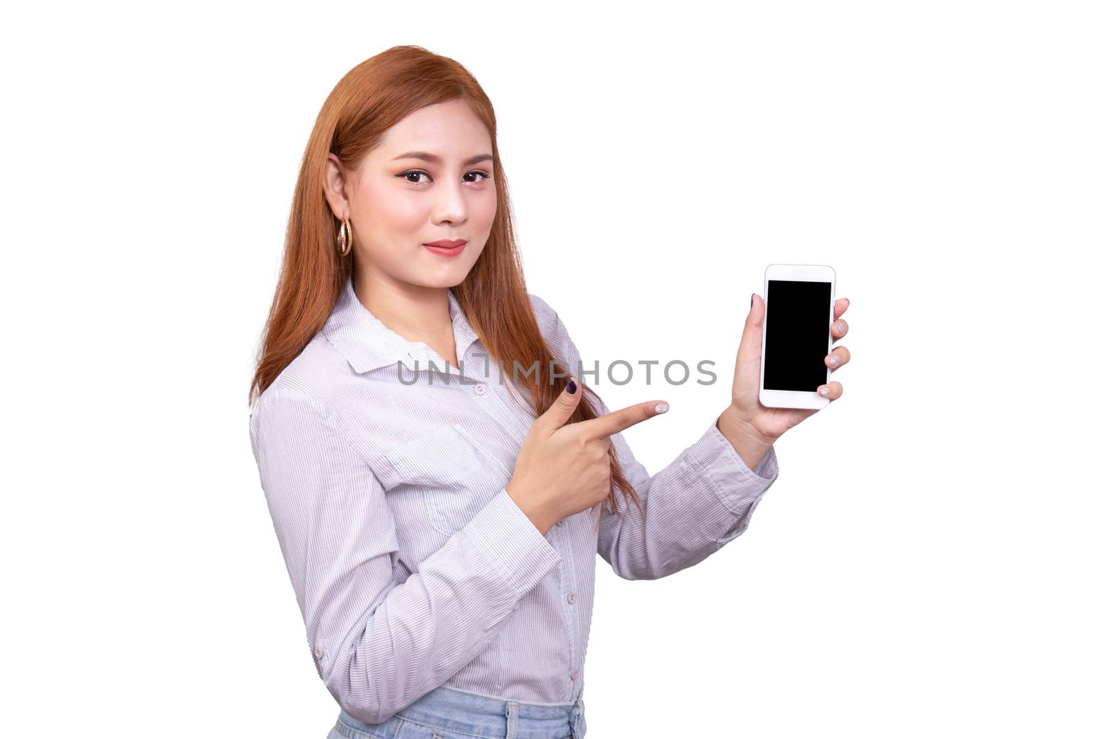 smiling Asian woman standing in casual shirt holding mobile phone and  pointing on smartphone isolated on white background with clipping path by asiandelight
