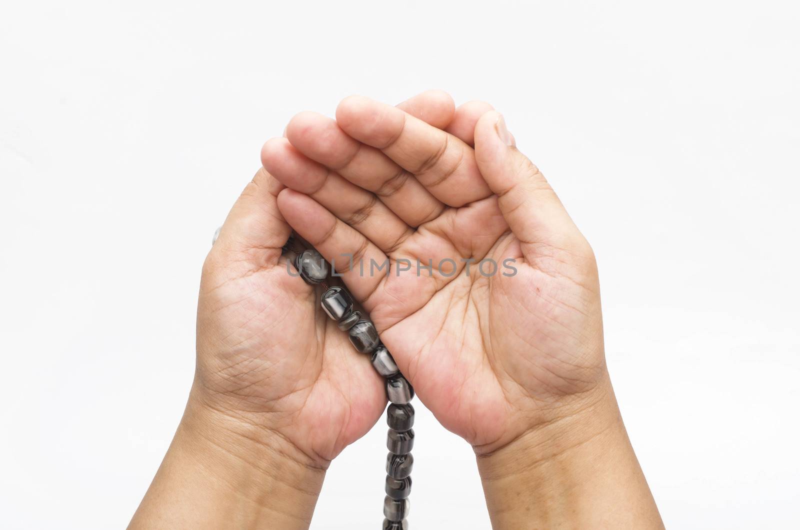 Hand holding muslim beads rosary or tasbih isolated on white background. Selective focus.