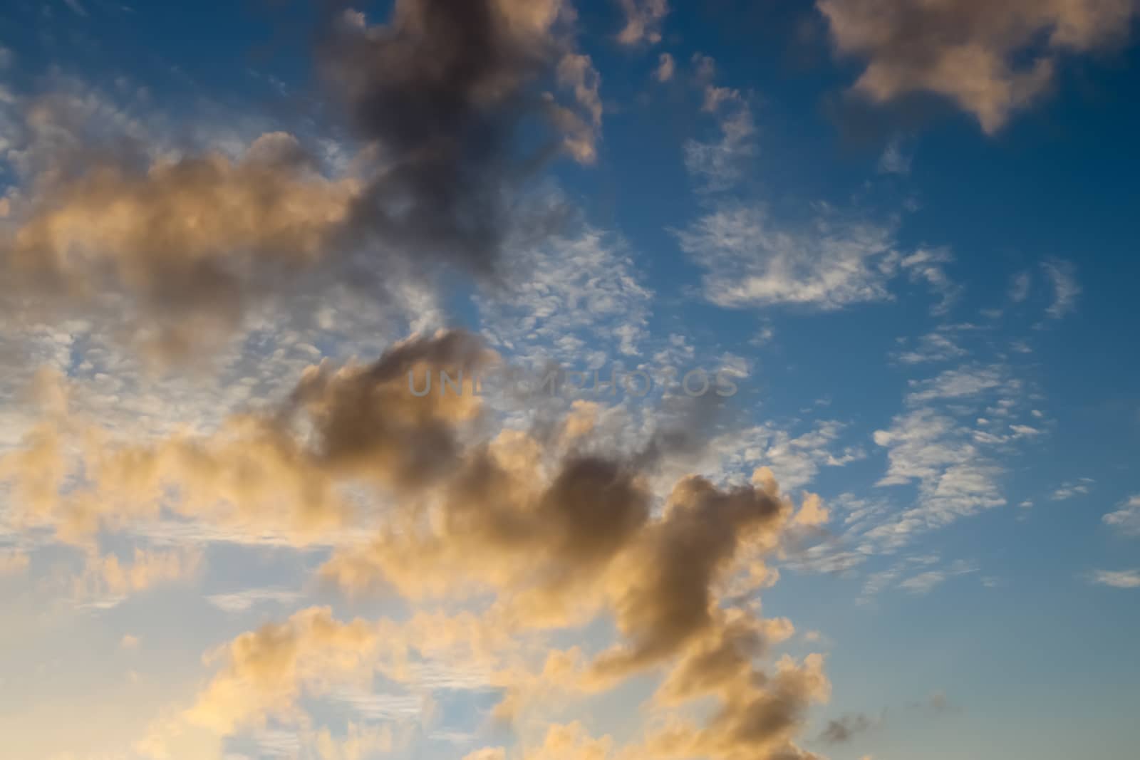 Beautiful panorama of orange and yellow clouds at sunrise and sunset in a blue sky