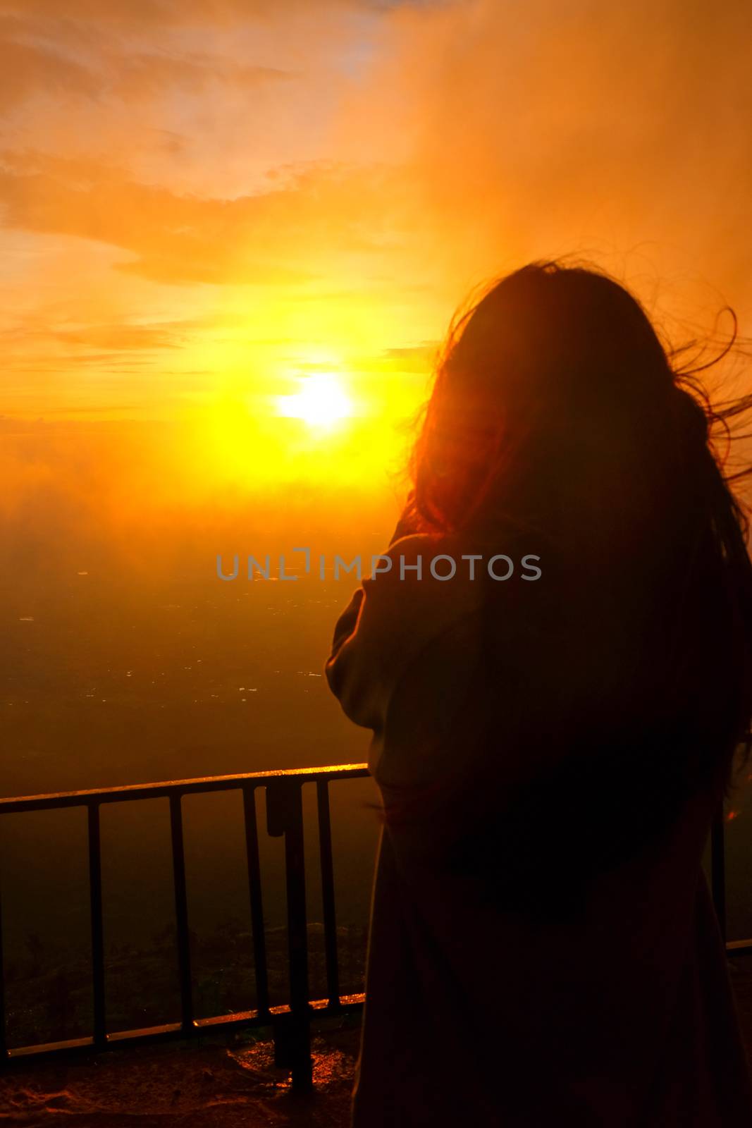 shadow of a woman standing to see the fog and the sunrise. by suthipong