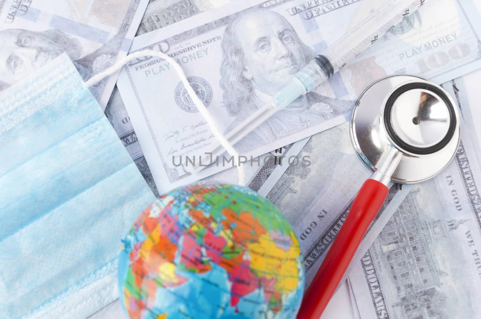 Medical face mask, stethoscope, syringe, world globe and banknotes on white background. Medical concept. Selective focus.