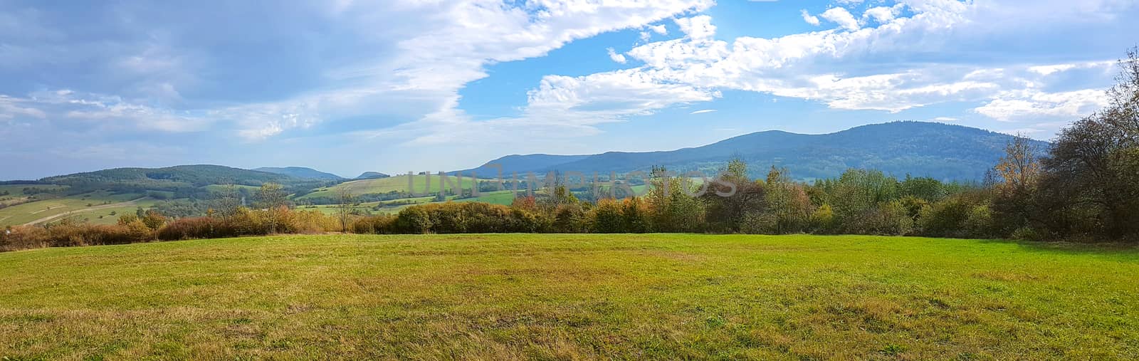 Wide panorama of idyllic autumn mountains landscape on a sunny day in the morning.