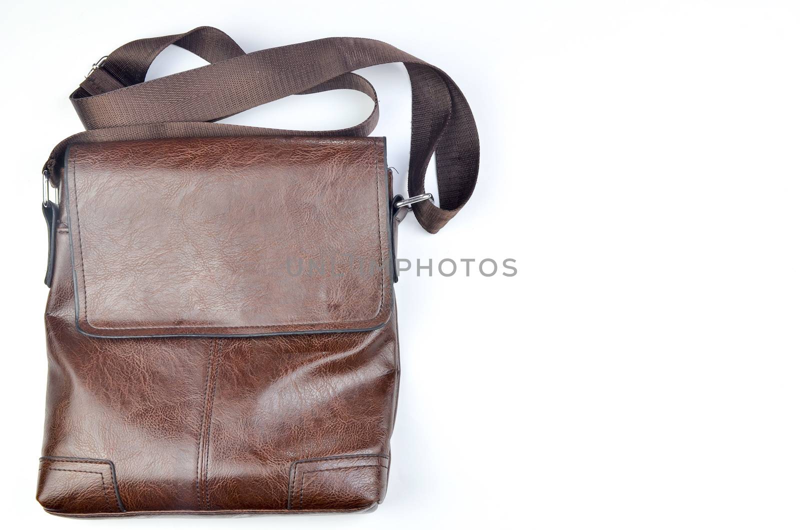 Brown sling bag on white background. Selective focus.