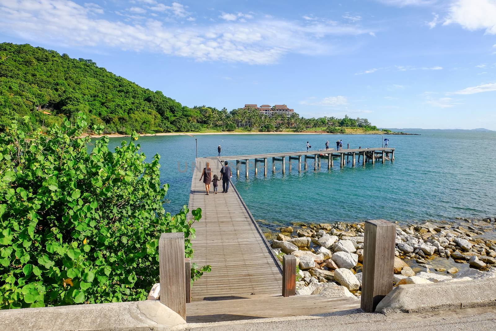 Family holiday with parents carrying children along the sea-side by suthipong