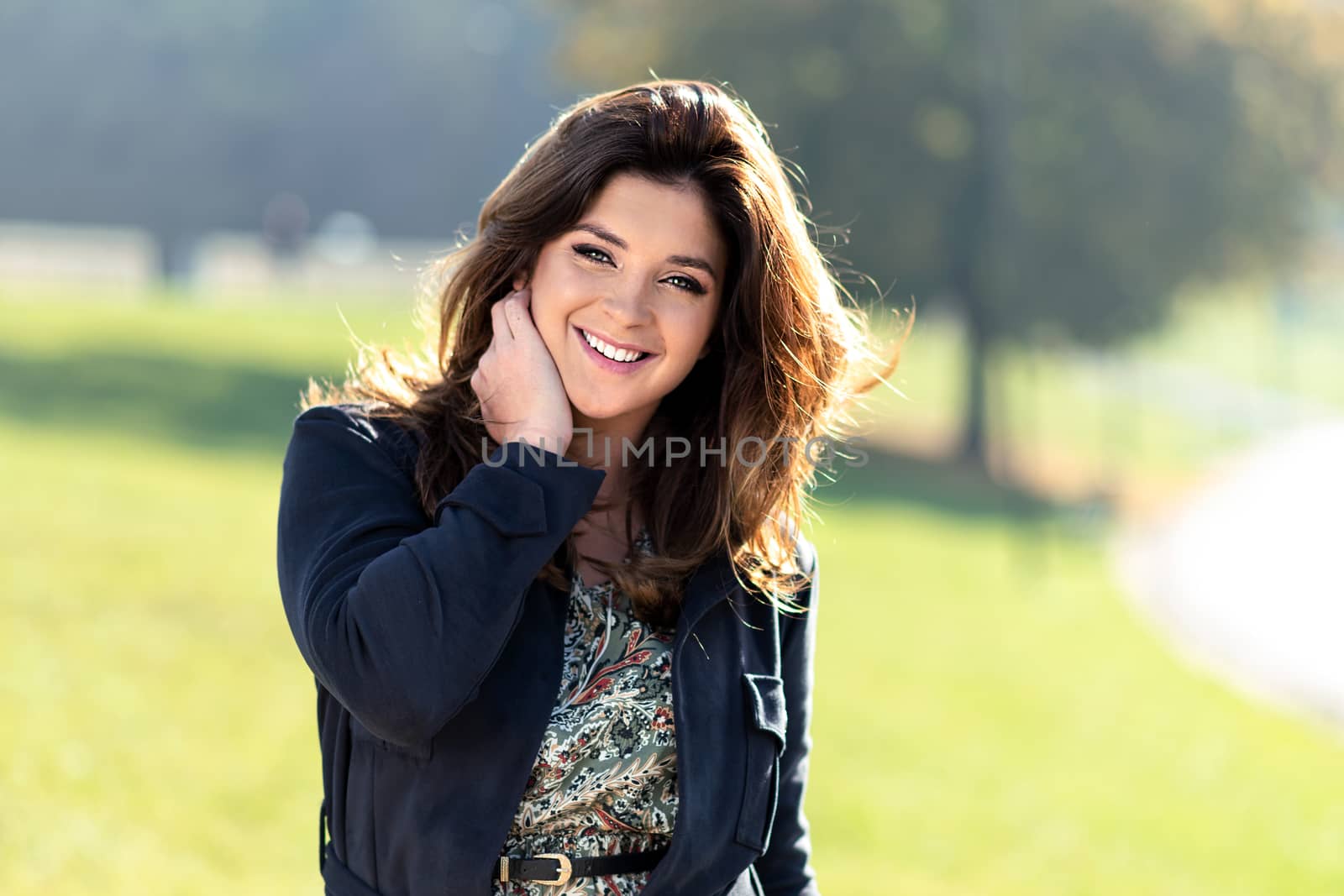 Portrait of a fashionable and lovely woman with nice hairstyle posing outdoor on a sunny day 
