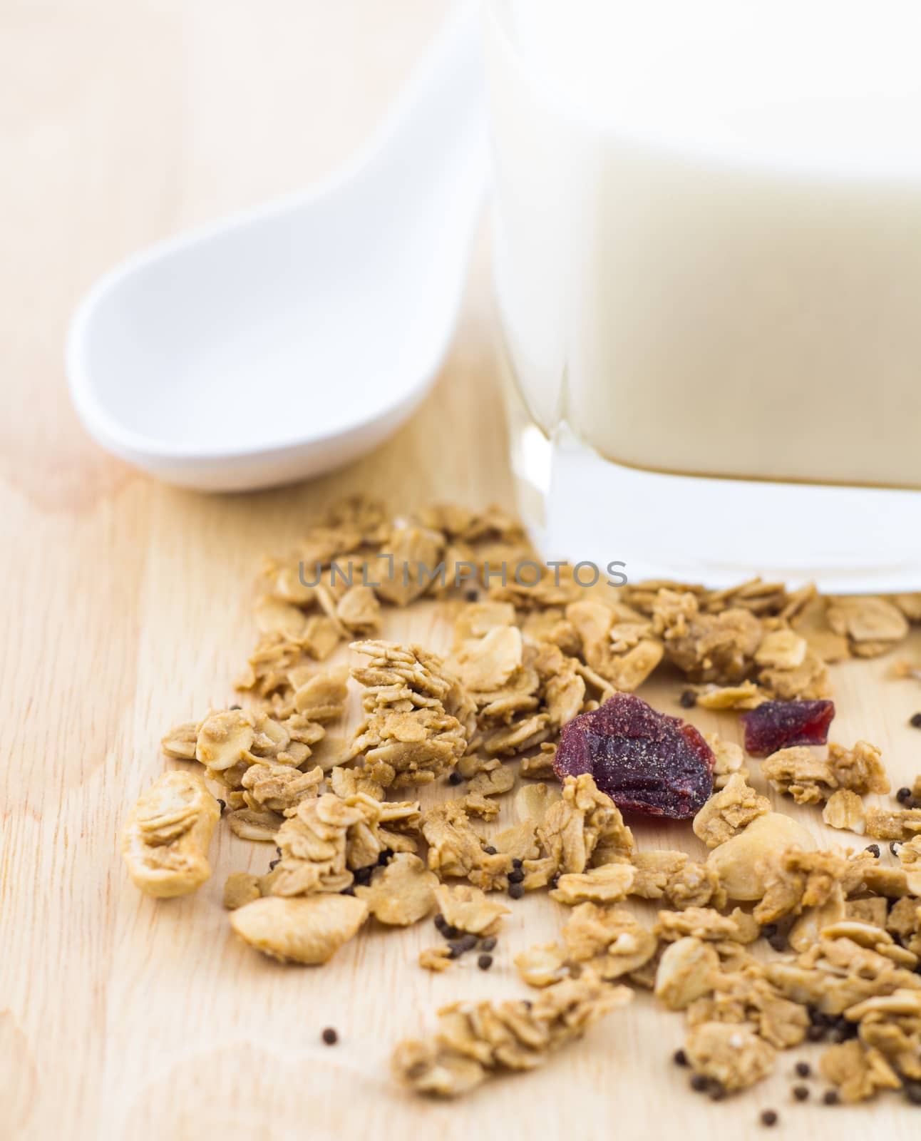 Fresh milk and cereal with spoon on wooden table
