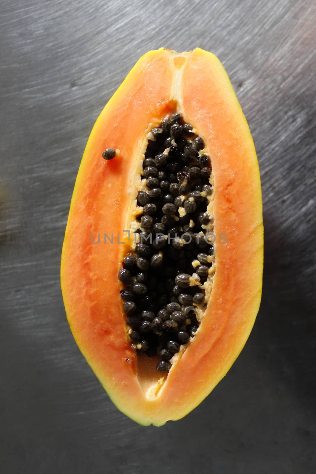 Half a papaya fruit on the kitchen table. by mahirrov