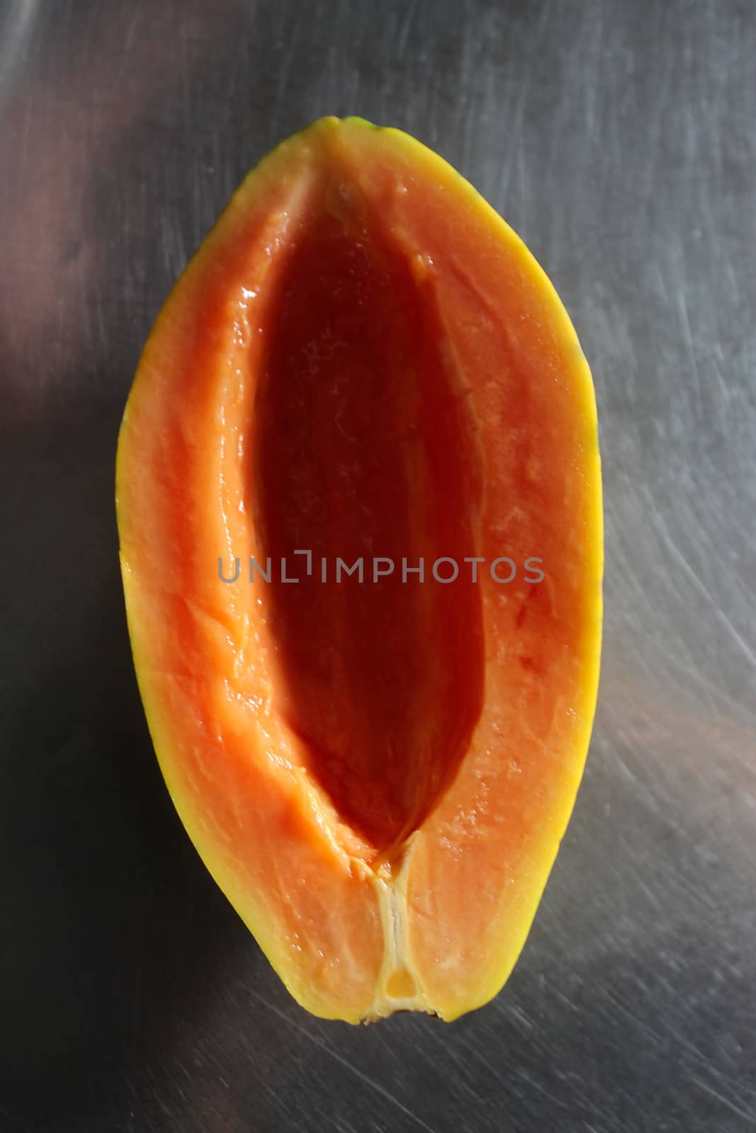 Half a papaya seedless fruit on the kitchen table. Papaya fruit. Papaya.