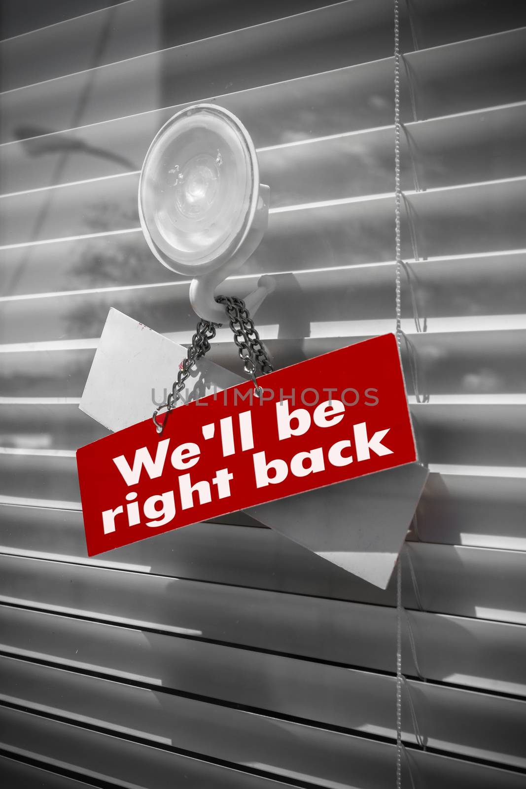 Sign saying "We'll be right back" on a glass door by germanopoli