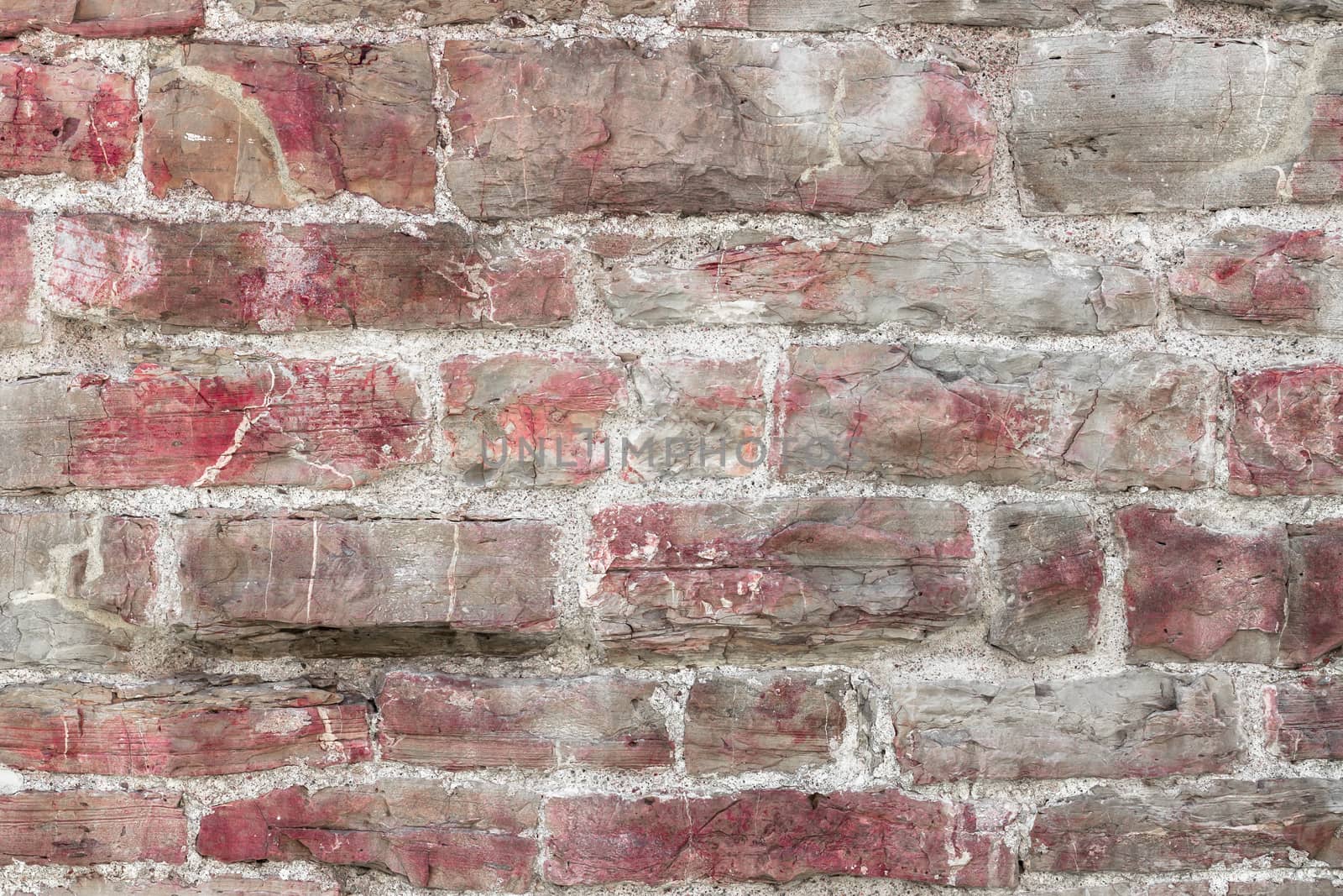 Red stone wall pattern. Close up of big concrete bricks outside.