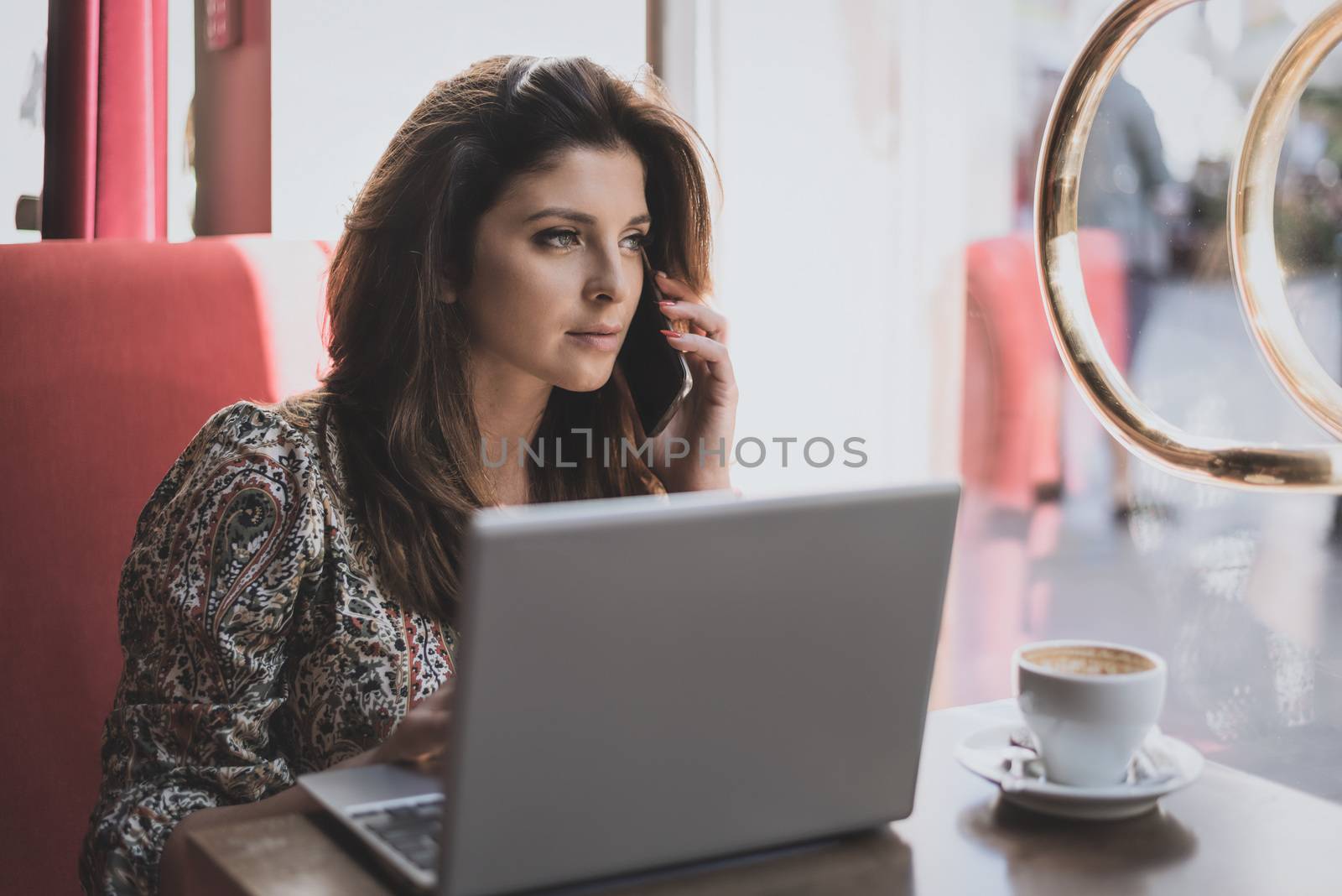 Beautiful young business woman working while drinking coffee in the restaurant.