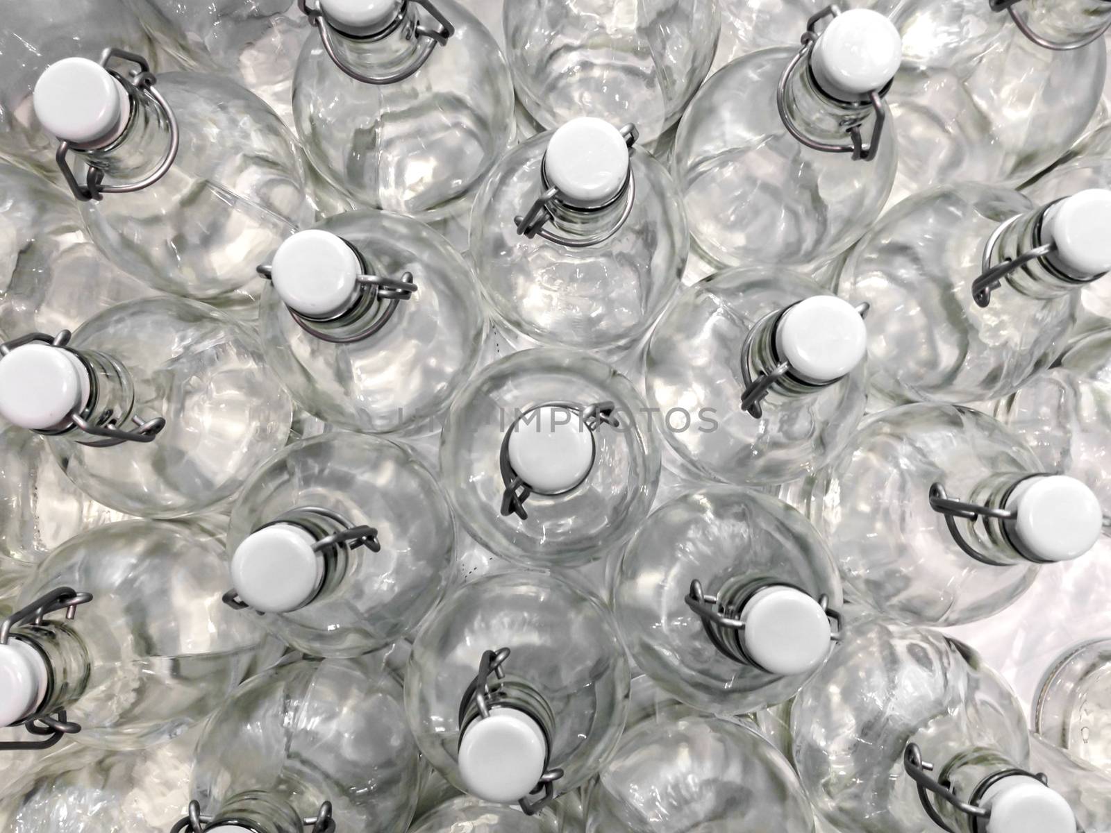 Transparent bottles seen from above. They can be filled with water, wine or other beverage. They are closed by a white plastic cap.