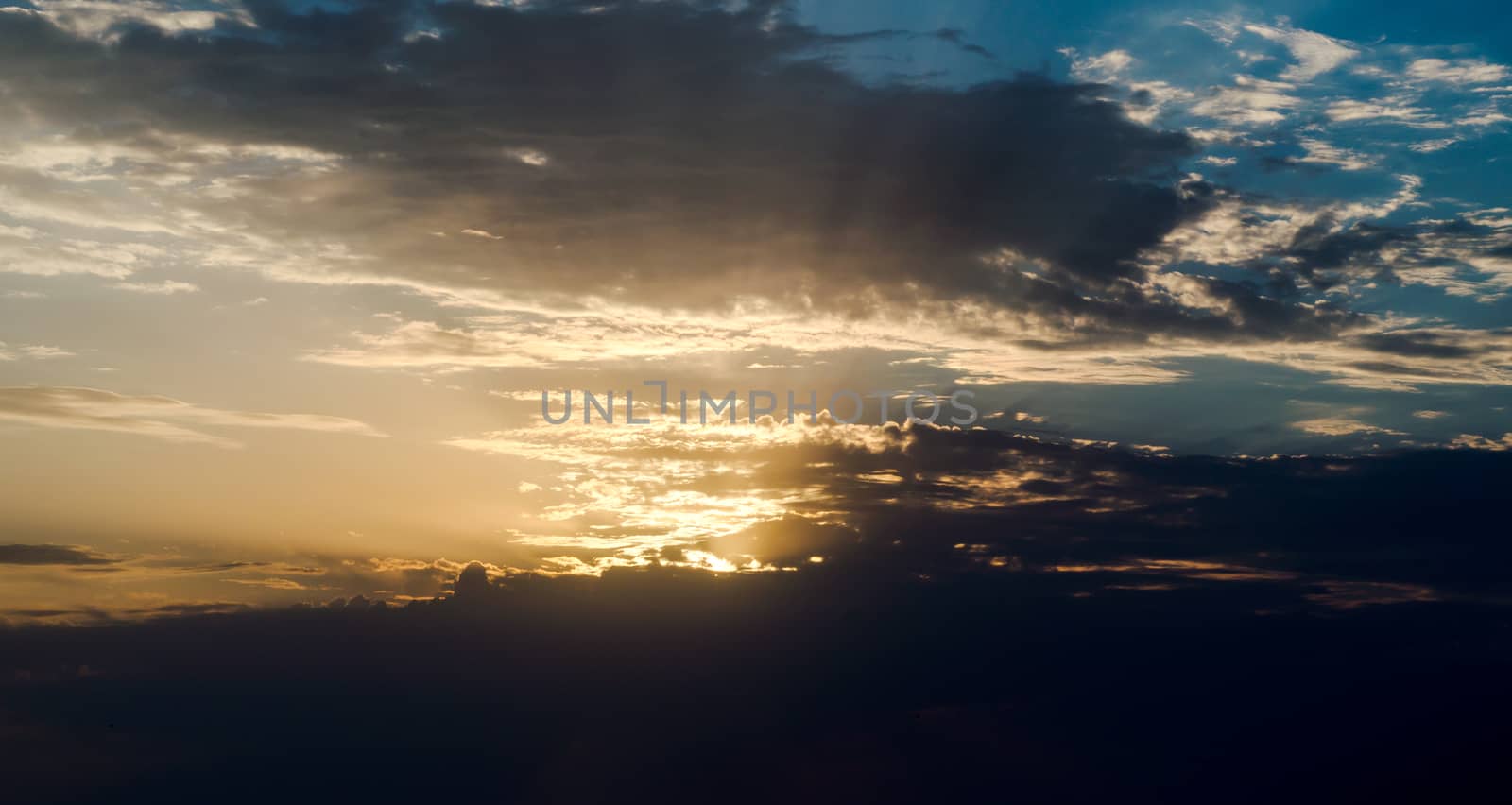 sky with clouds and rays of the setting sun landscape background nature