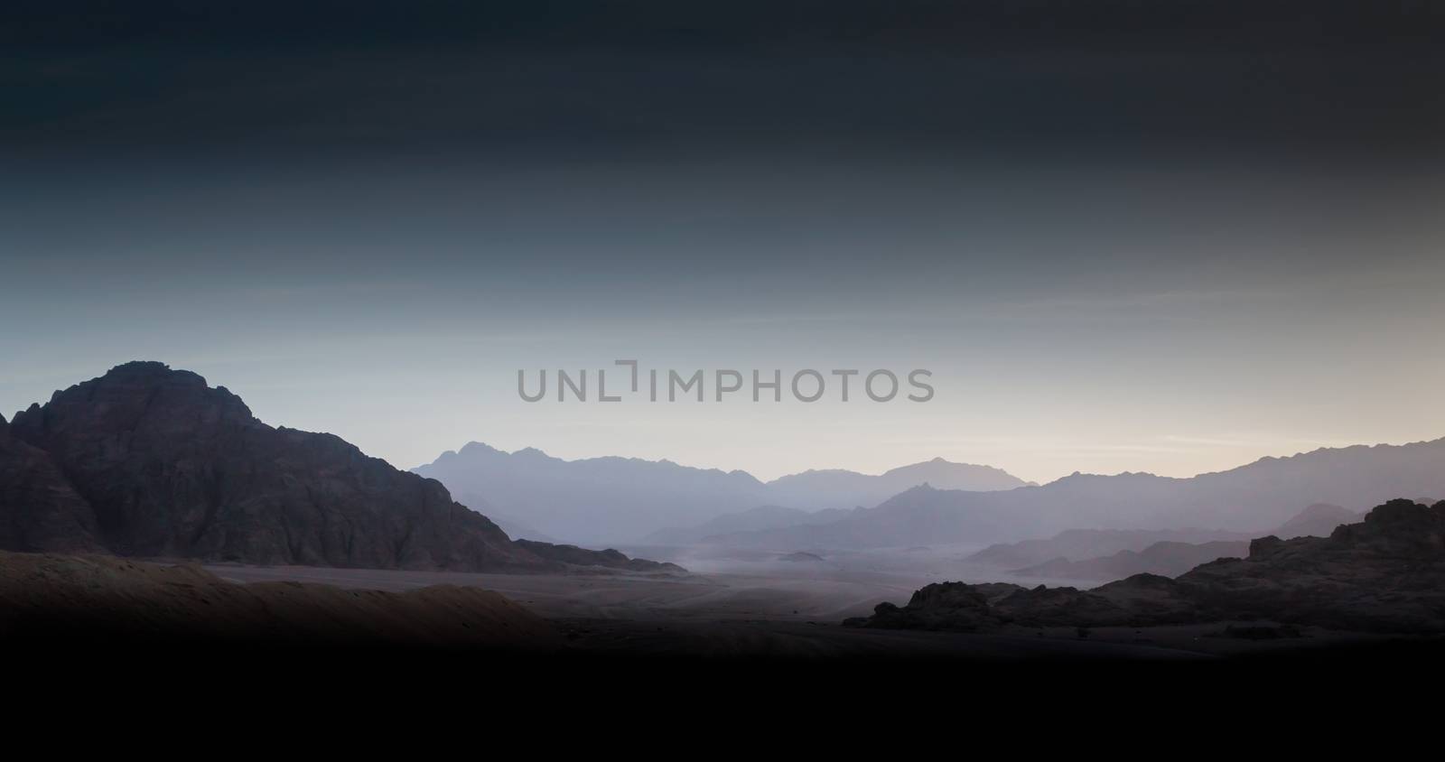 night desert landscape with rocky mountains and sunset sky with clouds in Sharm El Sheikh Egypt