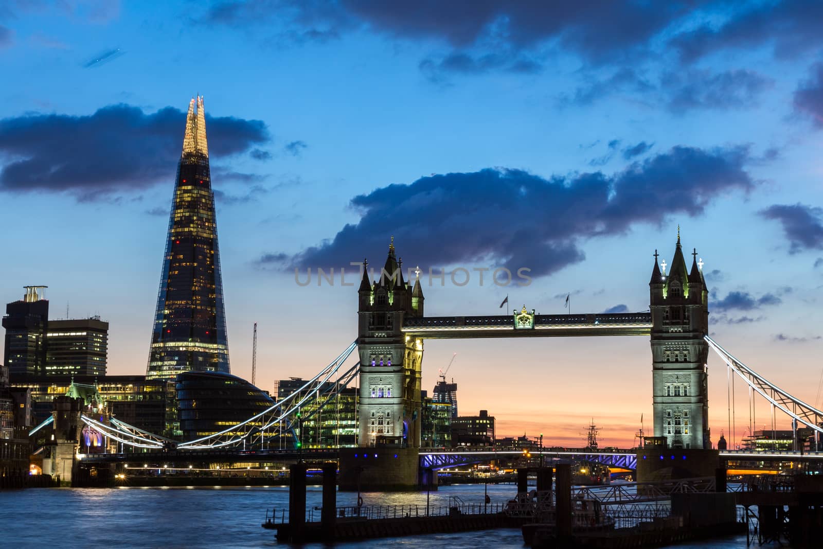 Tower Bridge, the Shard, city hall and business district in the background at night, London, Uk.