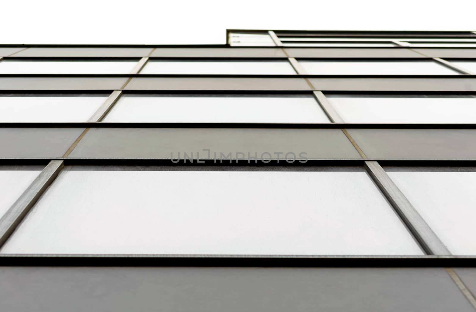 fragment of the wall and windows of a modern tall office building without people  abstract architectural monochromatic background