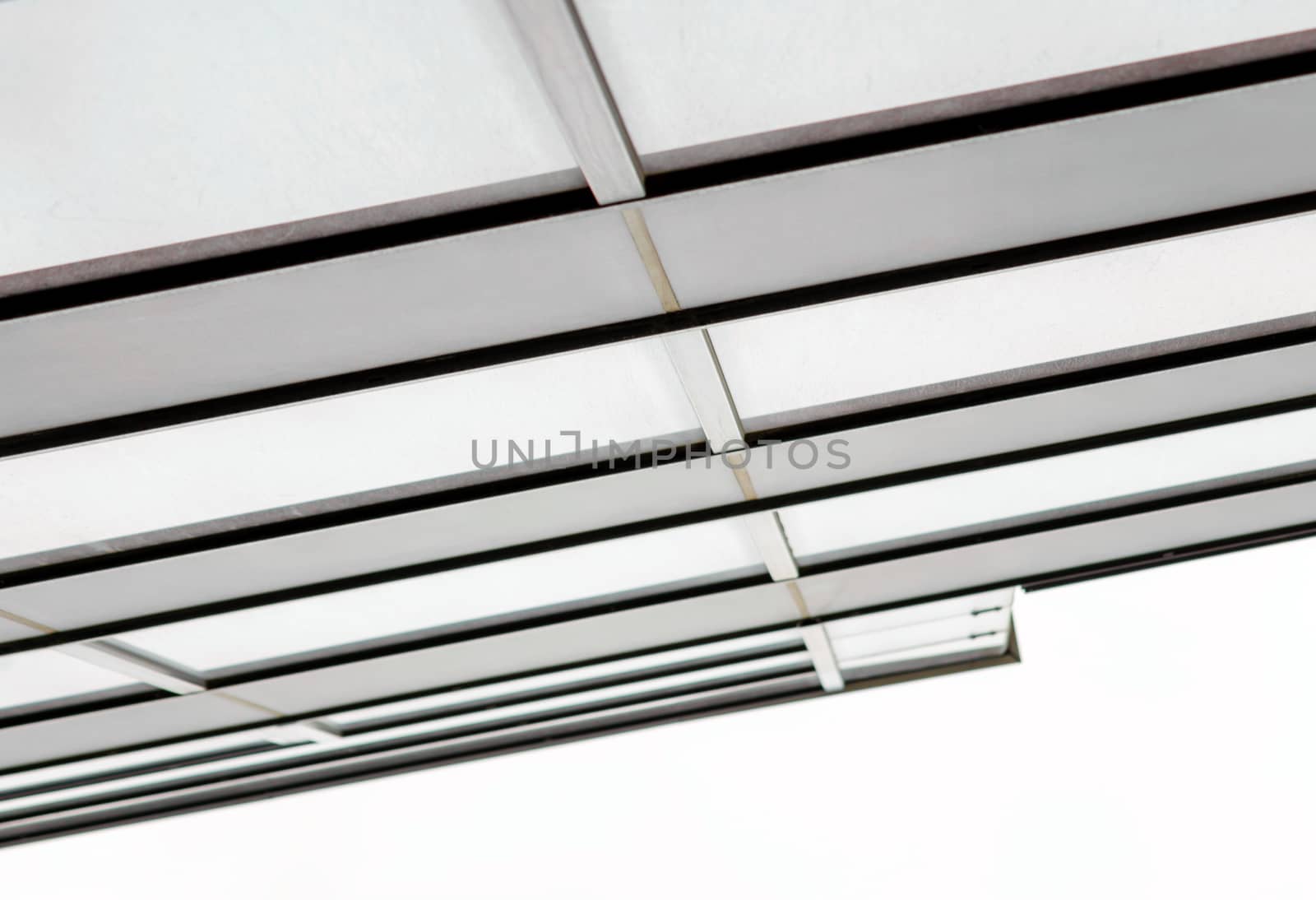 fragment of the wall and windows of a modern tall office building without people  abstract architectural monochromatic background