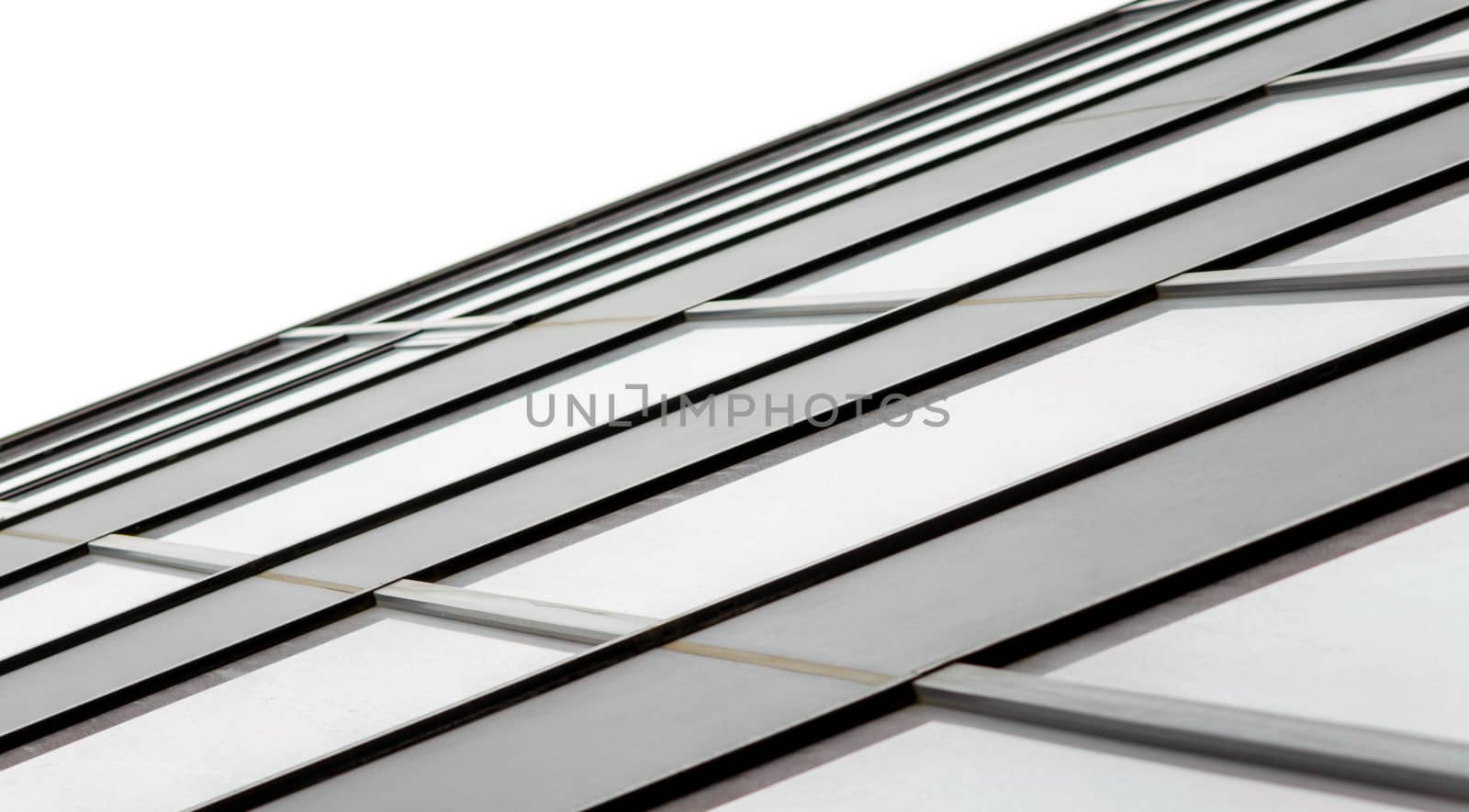 fragment of the wall and windows of a modern tall office building without people  abstract architectural monochromatic background