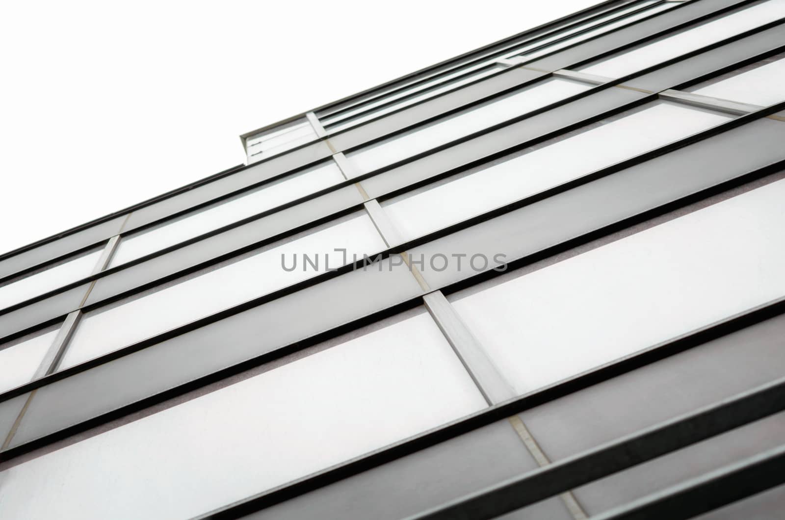 fragment of the wall and windows of a modern tall office building without people abstract architectural monochromatic background