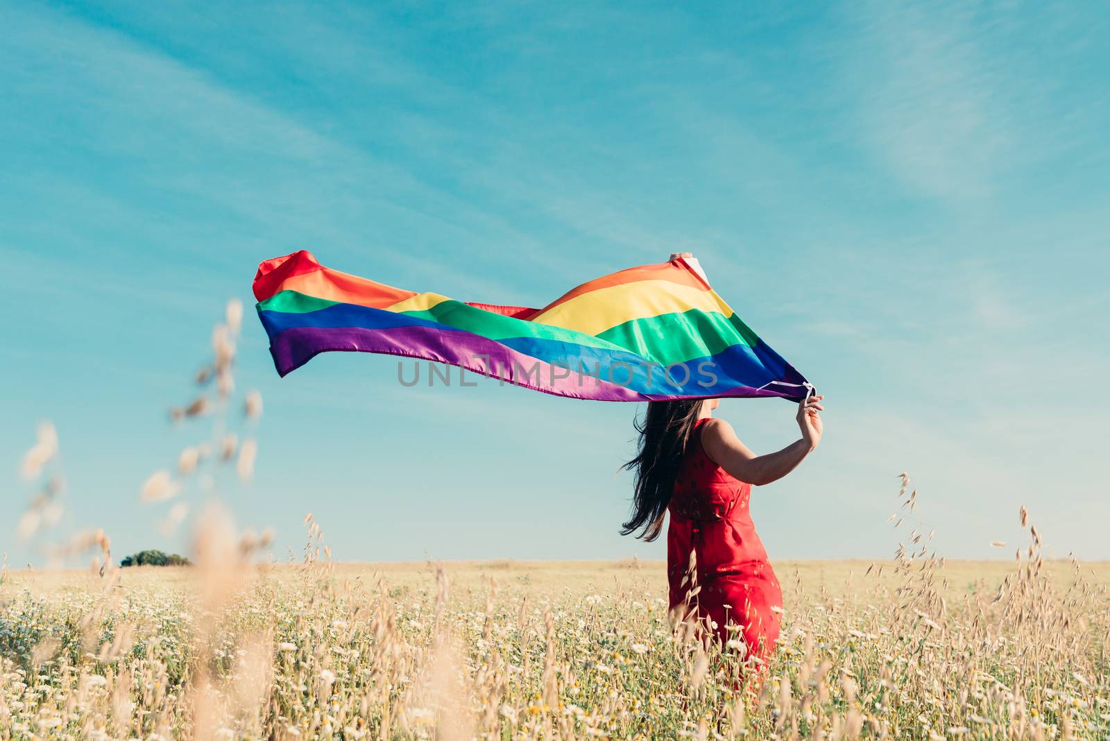 woman with lgbt flag on the field by Fotoeventis