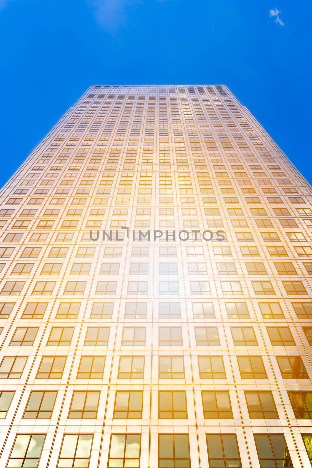 Bottom view of modern skyscrapers in business district against blue sky