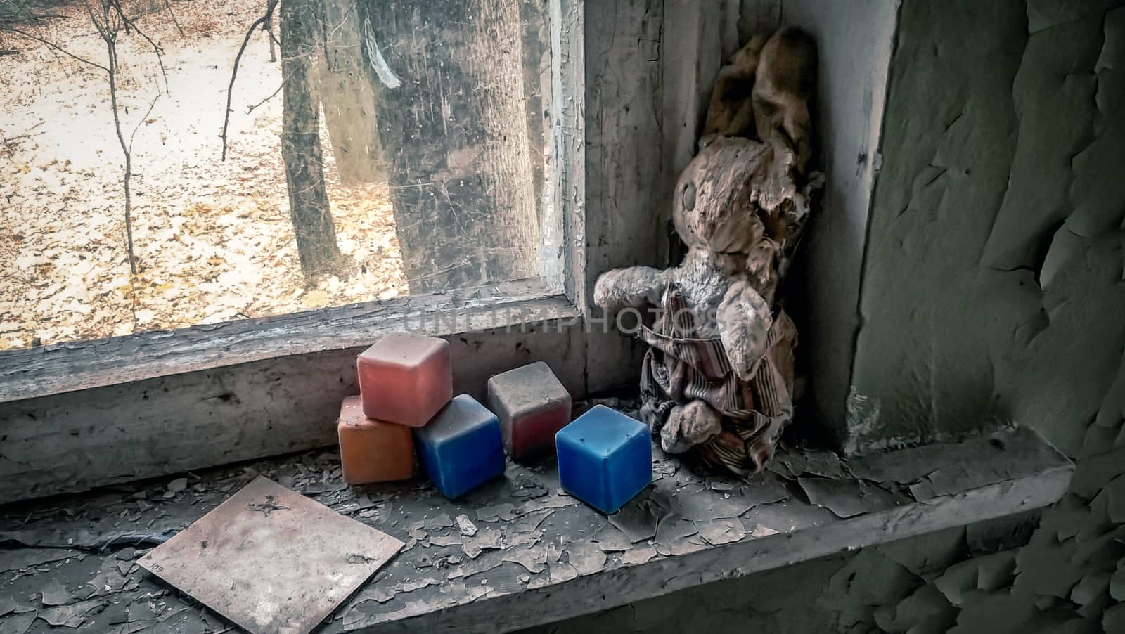 old toy and colored dusty cubes on a windowsill in an abandoned house in Chernobyl Ukraine