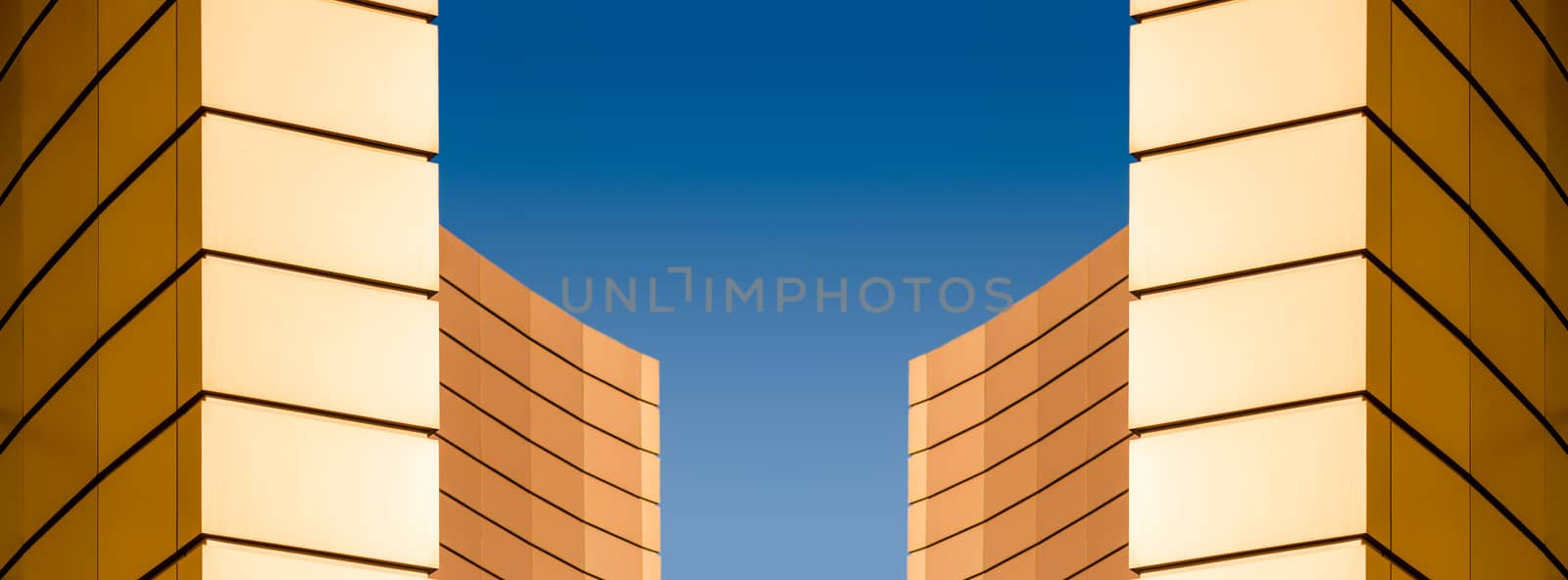 architectural abstract pattern fragment of a wall of a yellow modern building on a blue background