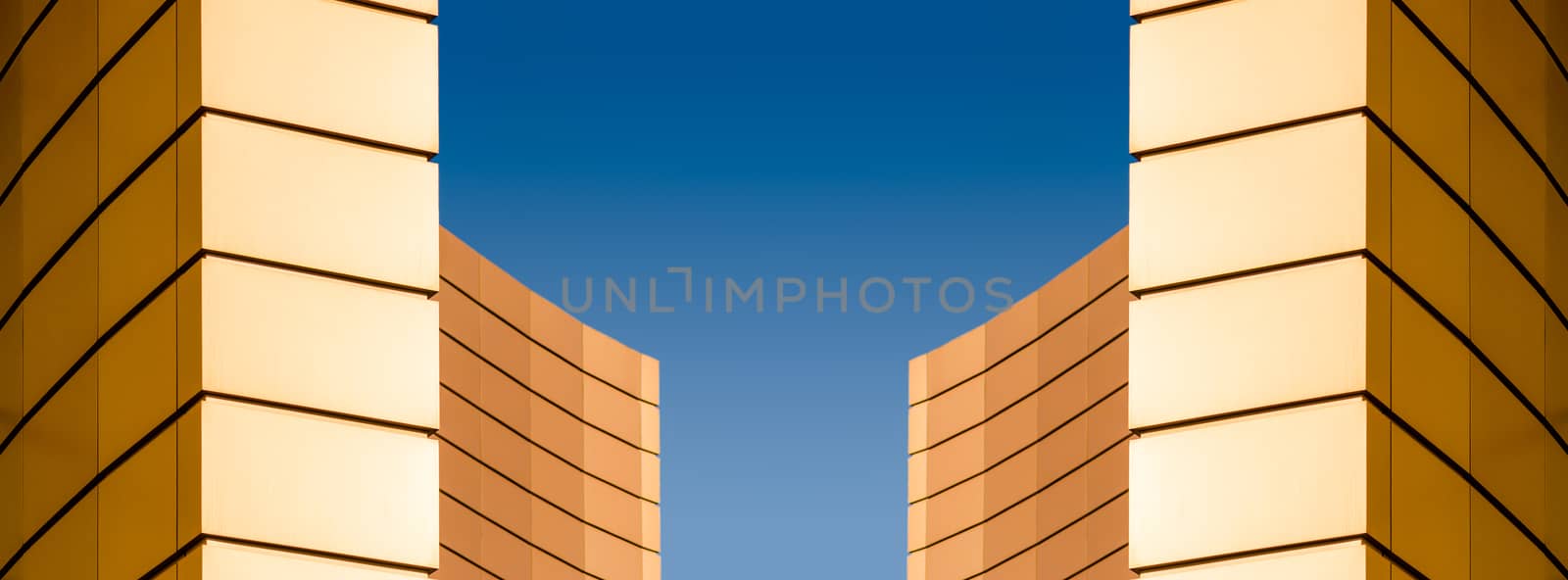 architectural abstract pattern fragment of a wall of a yellow modern building on a blue background