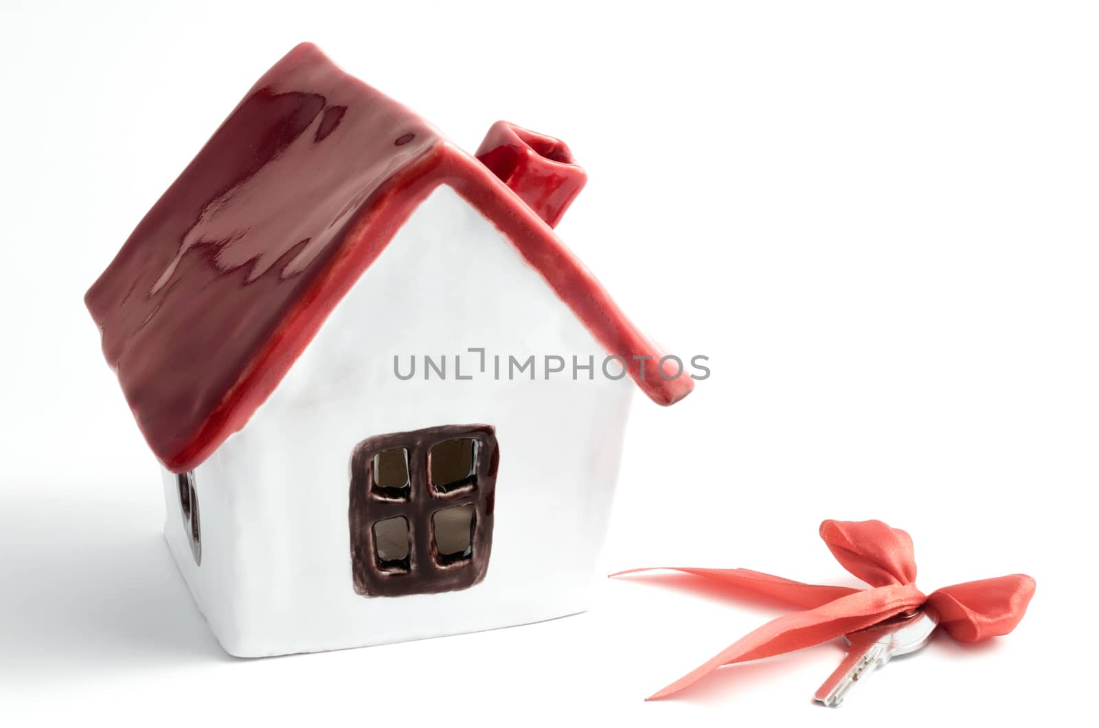 small white porcelain house with red roof and key housewarming rental purchase on a white background isolated