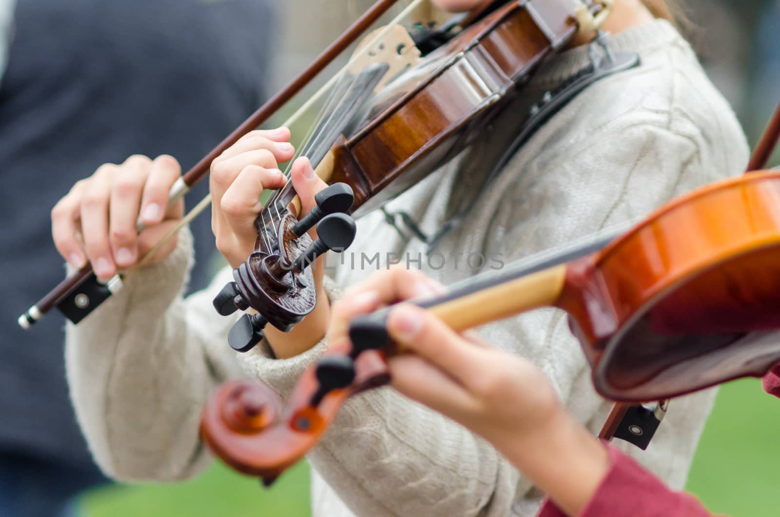 hands of a street musician girl with violin closeup