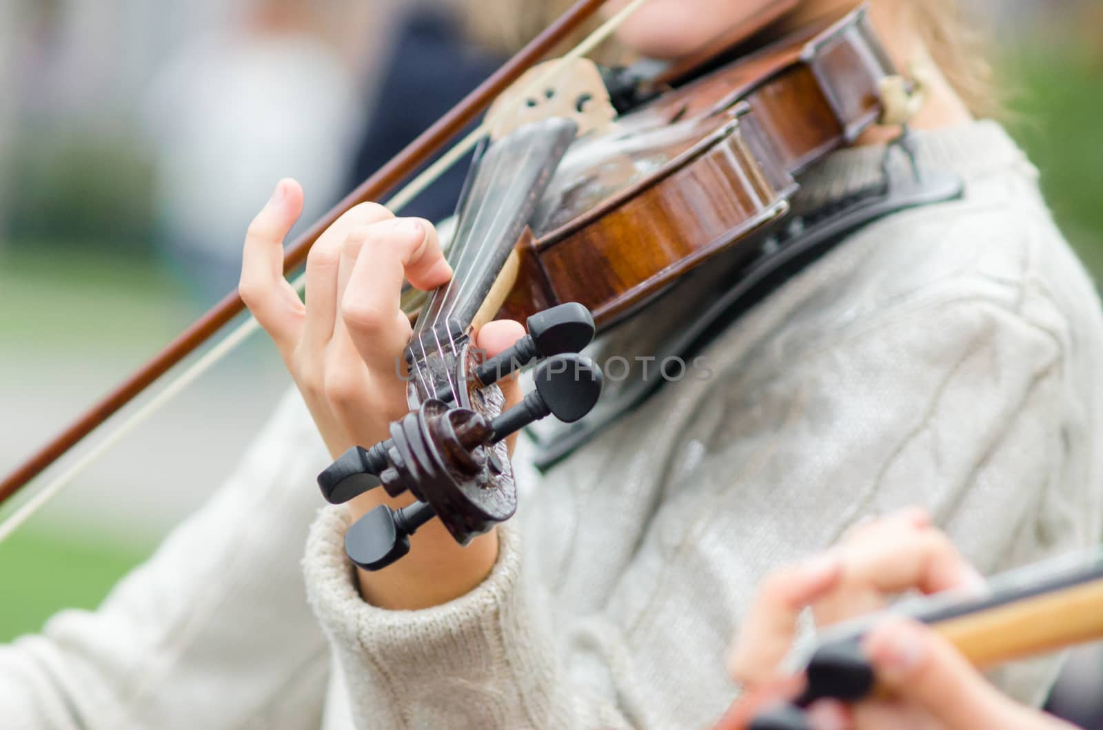hands of a street musician girl with violin closeup