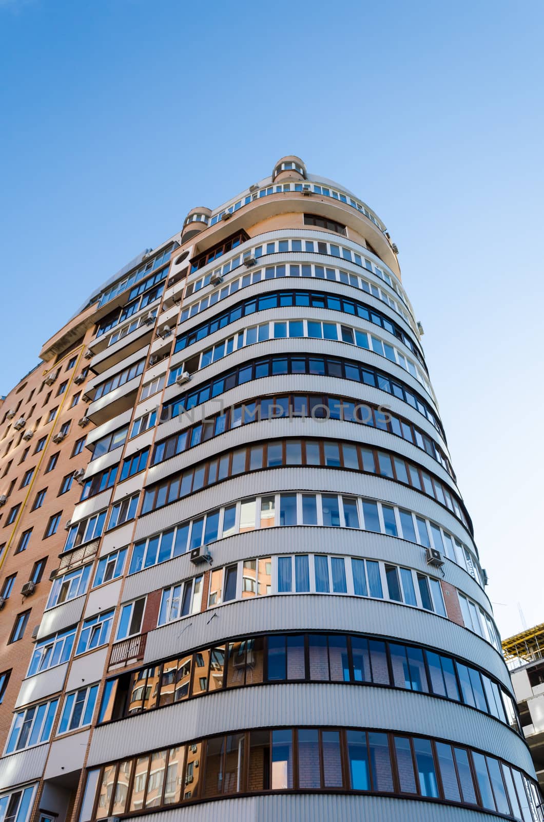 real estate high-rise semi-circular residential building against a blue sky