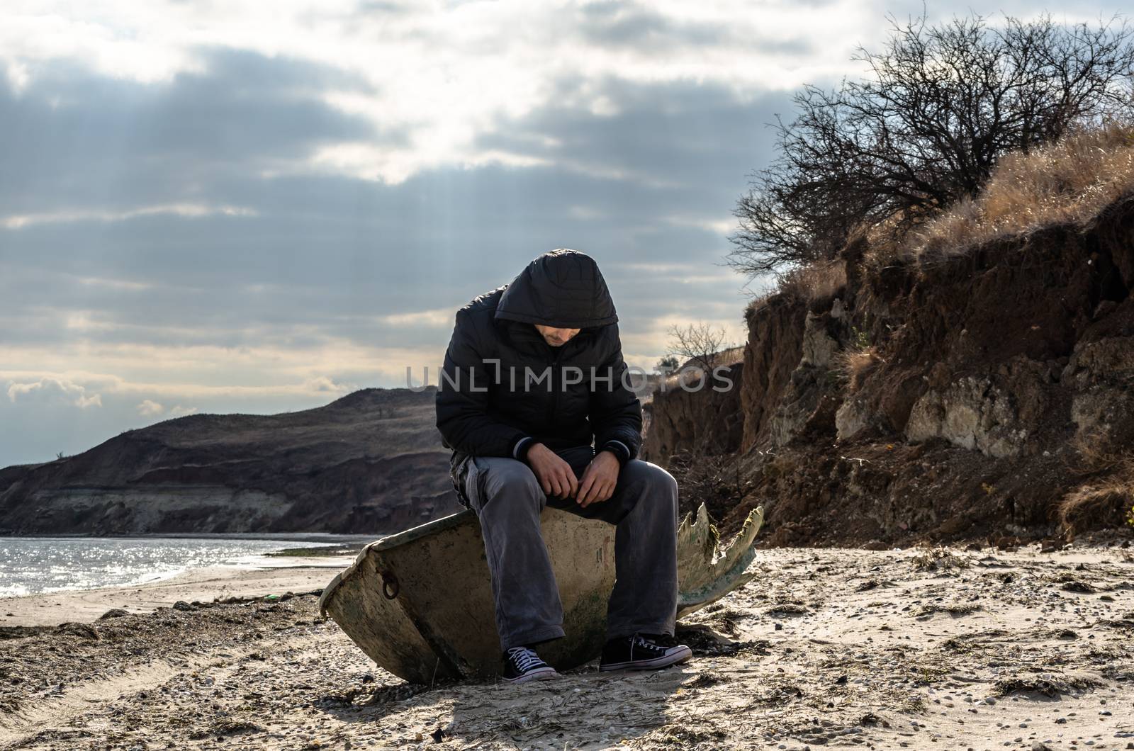 man in black sitting aboard a broken boat