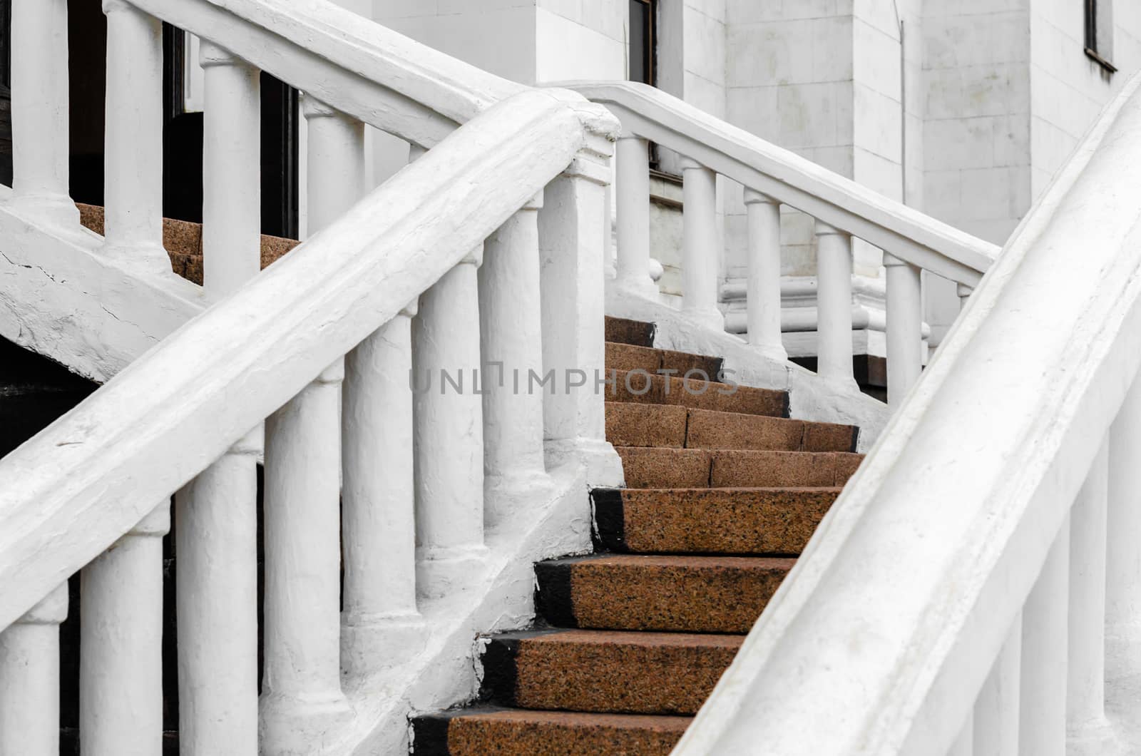 stone steps of an old house with white railing closeup