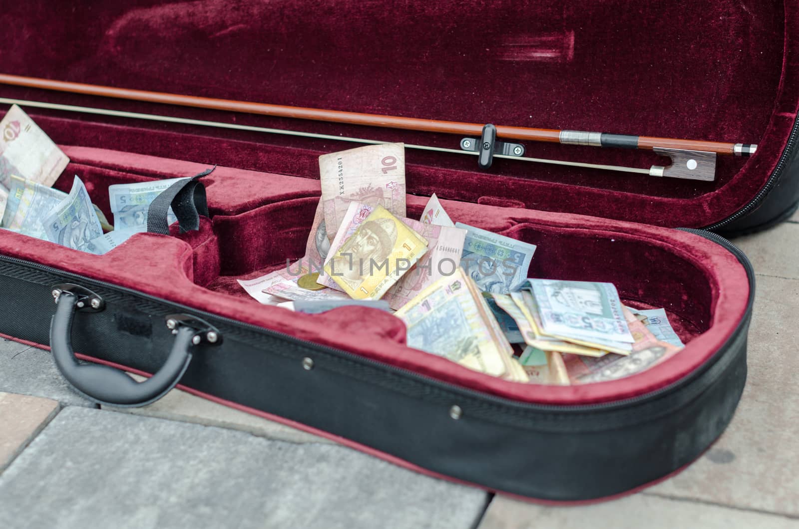 ukrainian money bills in a case of a street musician closeup