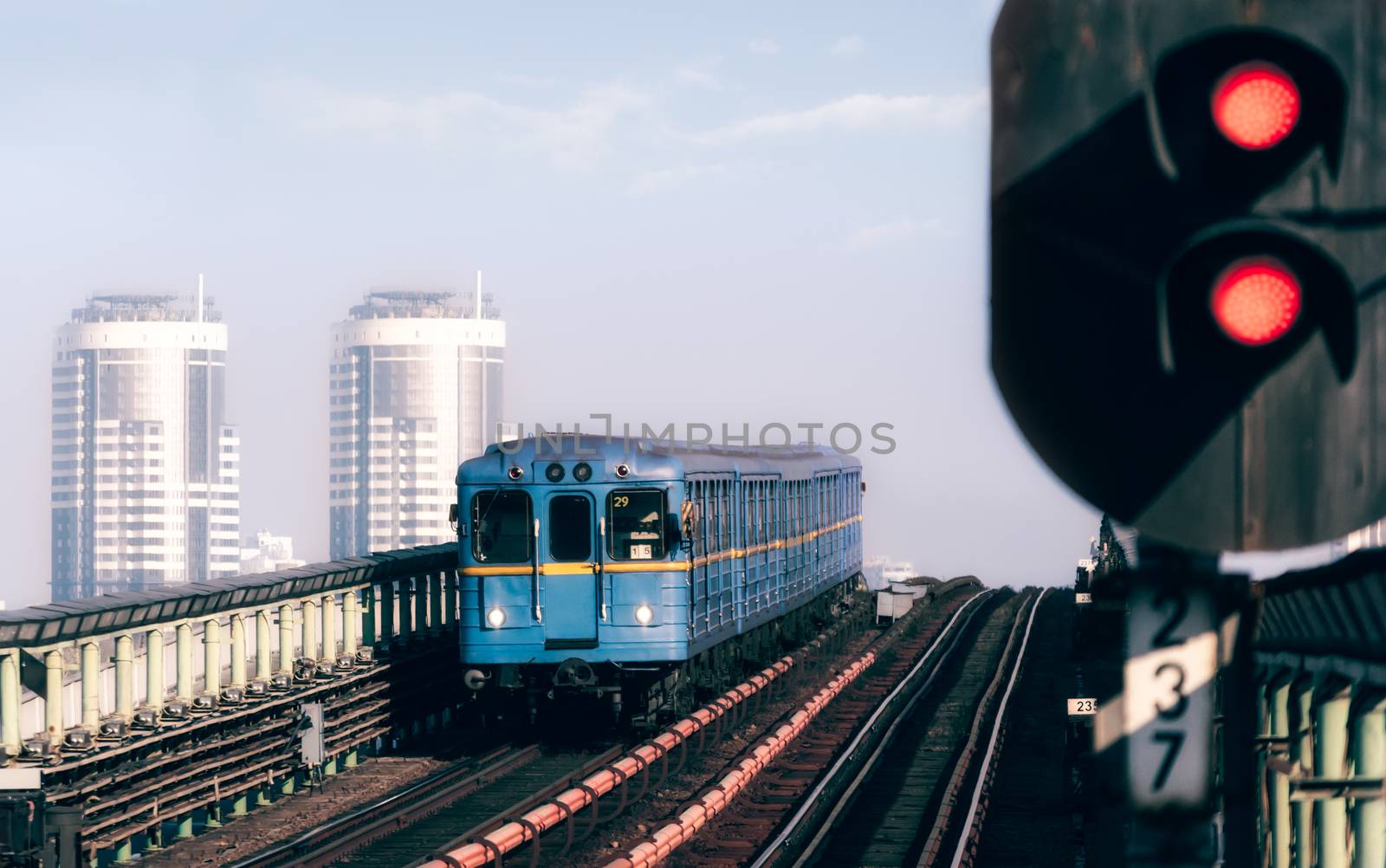 blue classic subway cars on the background of office skyscrapers and
red stop lamp in Kiev Ukraine in the morning