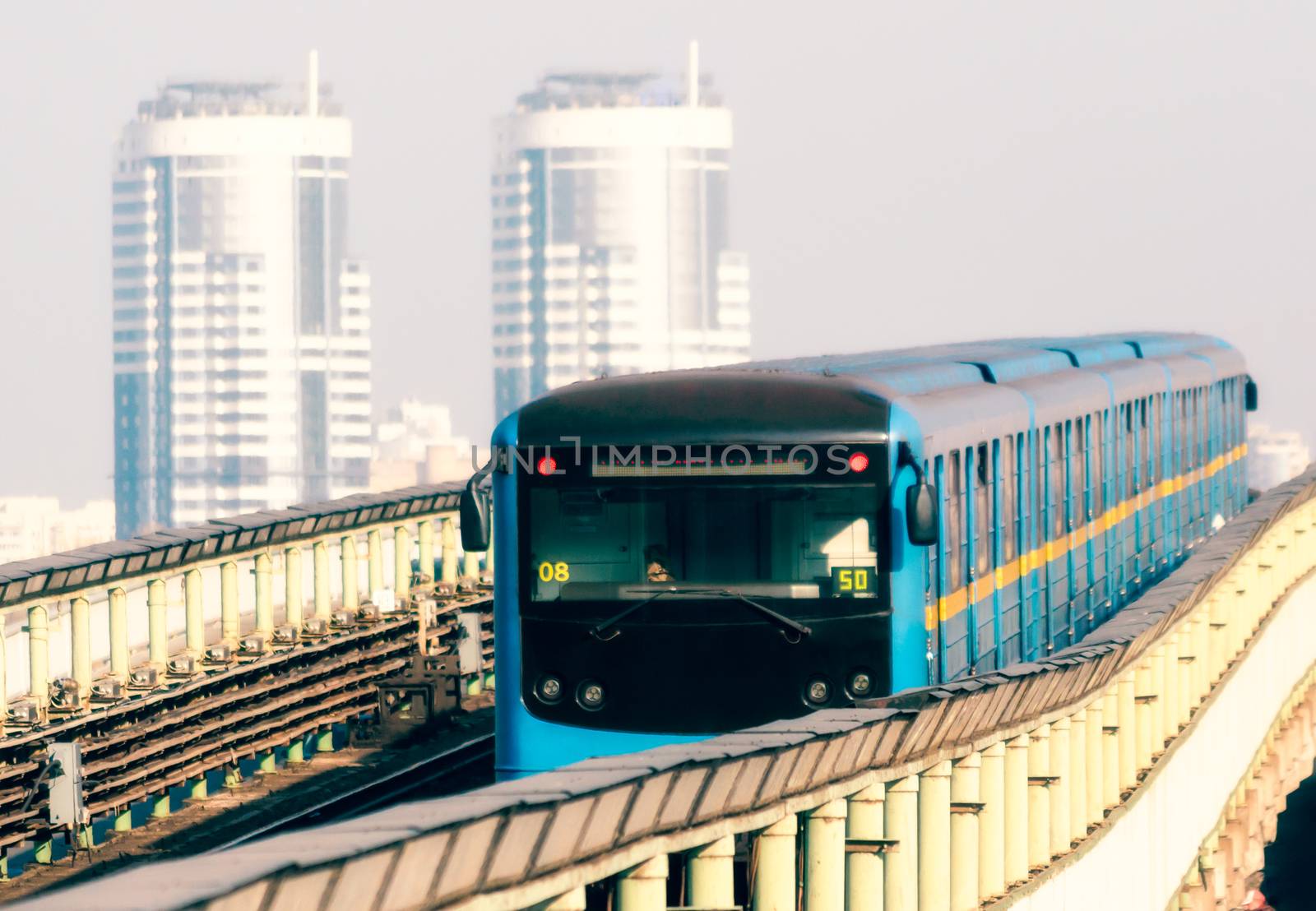 blue modern metro cars on the background of office skyscrapers in Kiev Ukraine in the morning