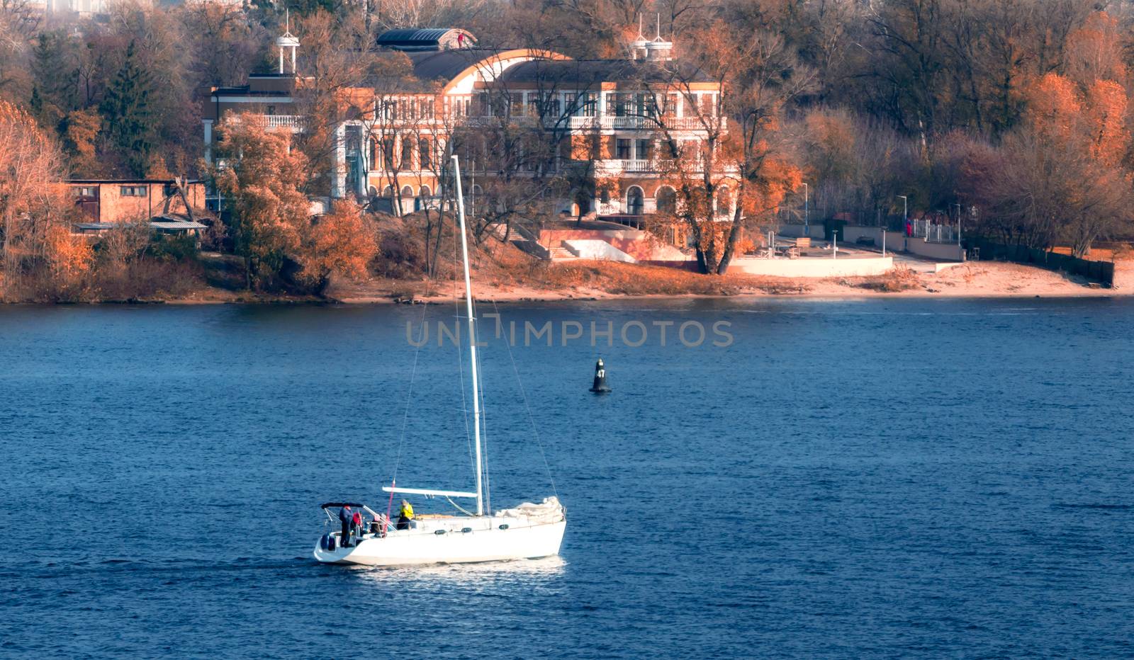 yacht with a tourists on the background of the coast and the city of Kiev Ukraine in the autumn morning