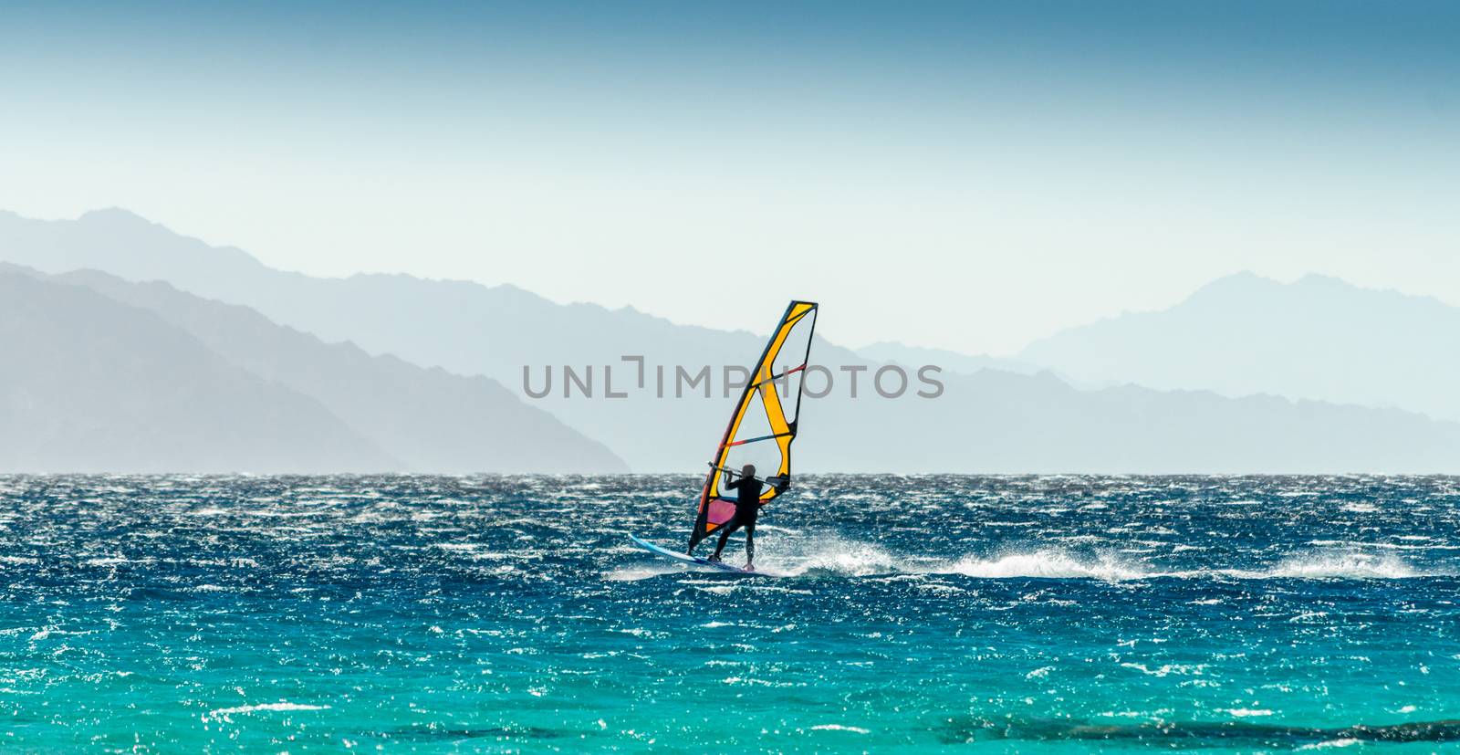 windsurfer rides on a background of high mountains in Egypt Dahab