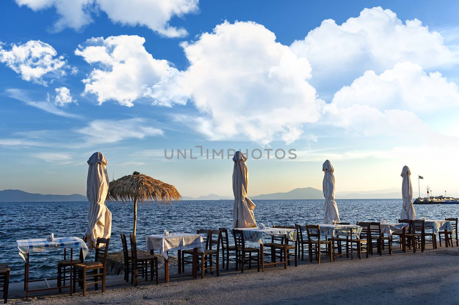 Mediterranean sea scenery, greek tavern tables and umbrellas