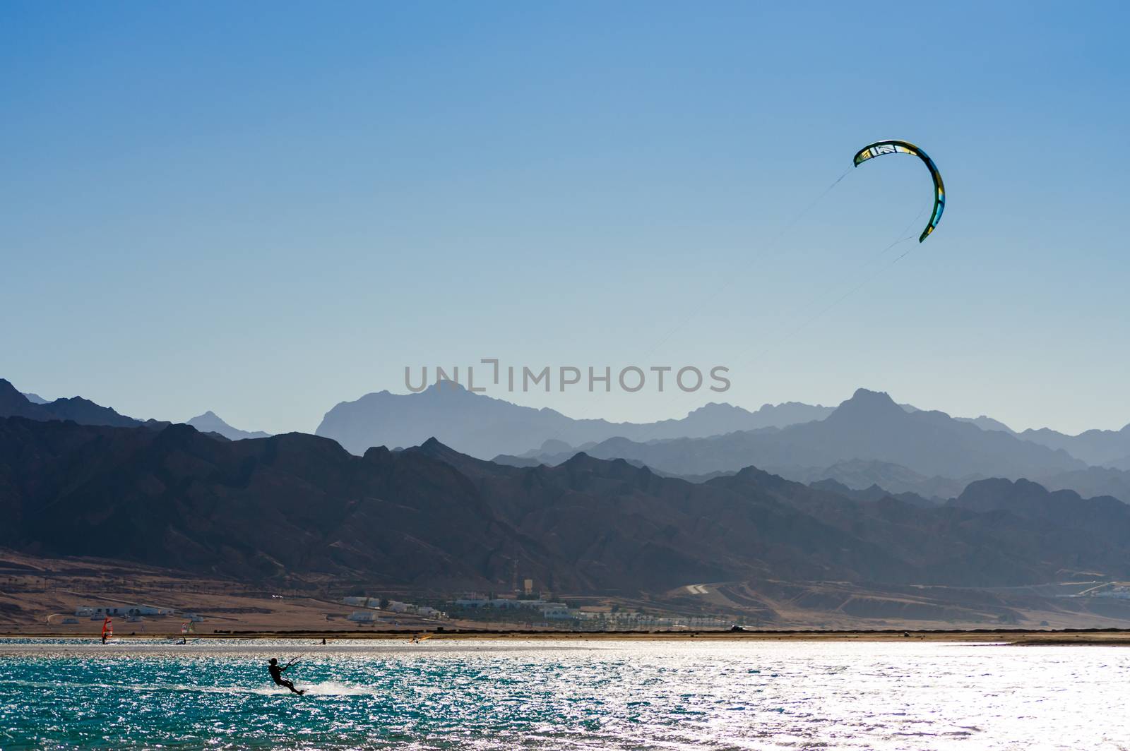 kitesurfer rides in the Red Sea on the background of a rocky coast in Egypt Dahab