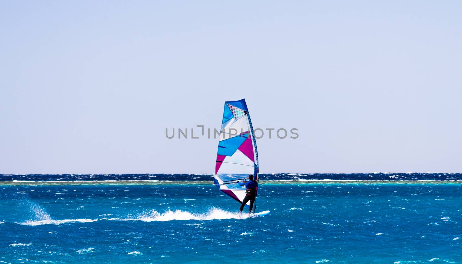 windsurfer rides on the waves of the Red Sea in Egypt Dahab