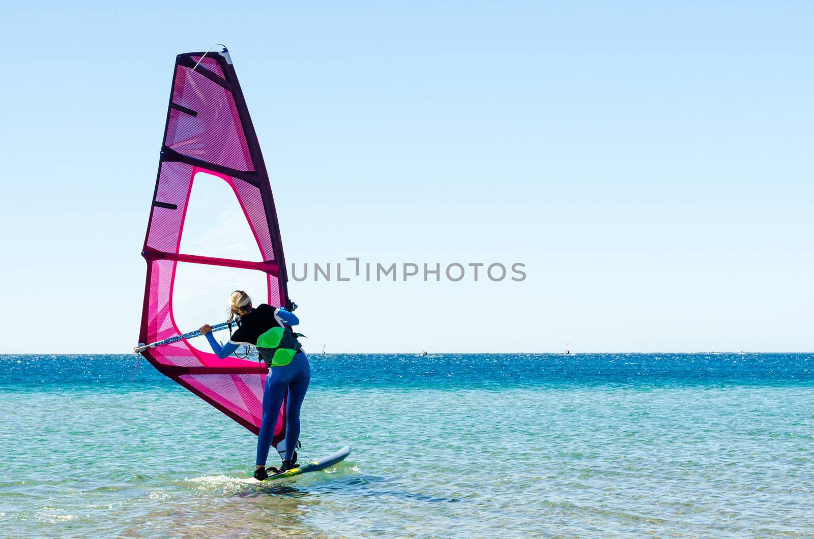 young girl windsurfer beginner learns to ride in the sea in Egypt Dahab