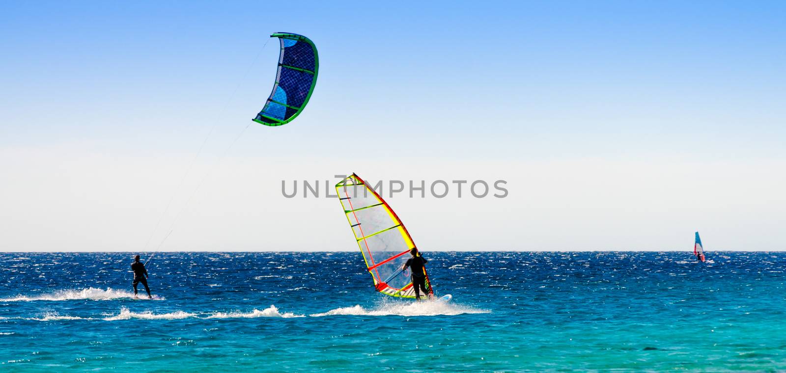 windsurfers and kitesurfers ride in the Red Sea in Egypt Dahab